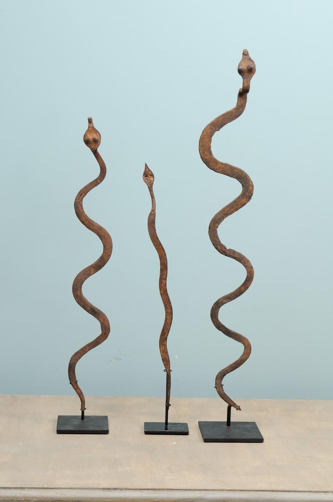 A collection of Burkina Faso currency from the mid-20th century. This assortment of three vintage African ritual iron snakes effigies originate from the Lobi tribe of Burkina Faso. These serpent shaped currencies are made of iron, have a lovely