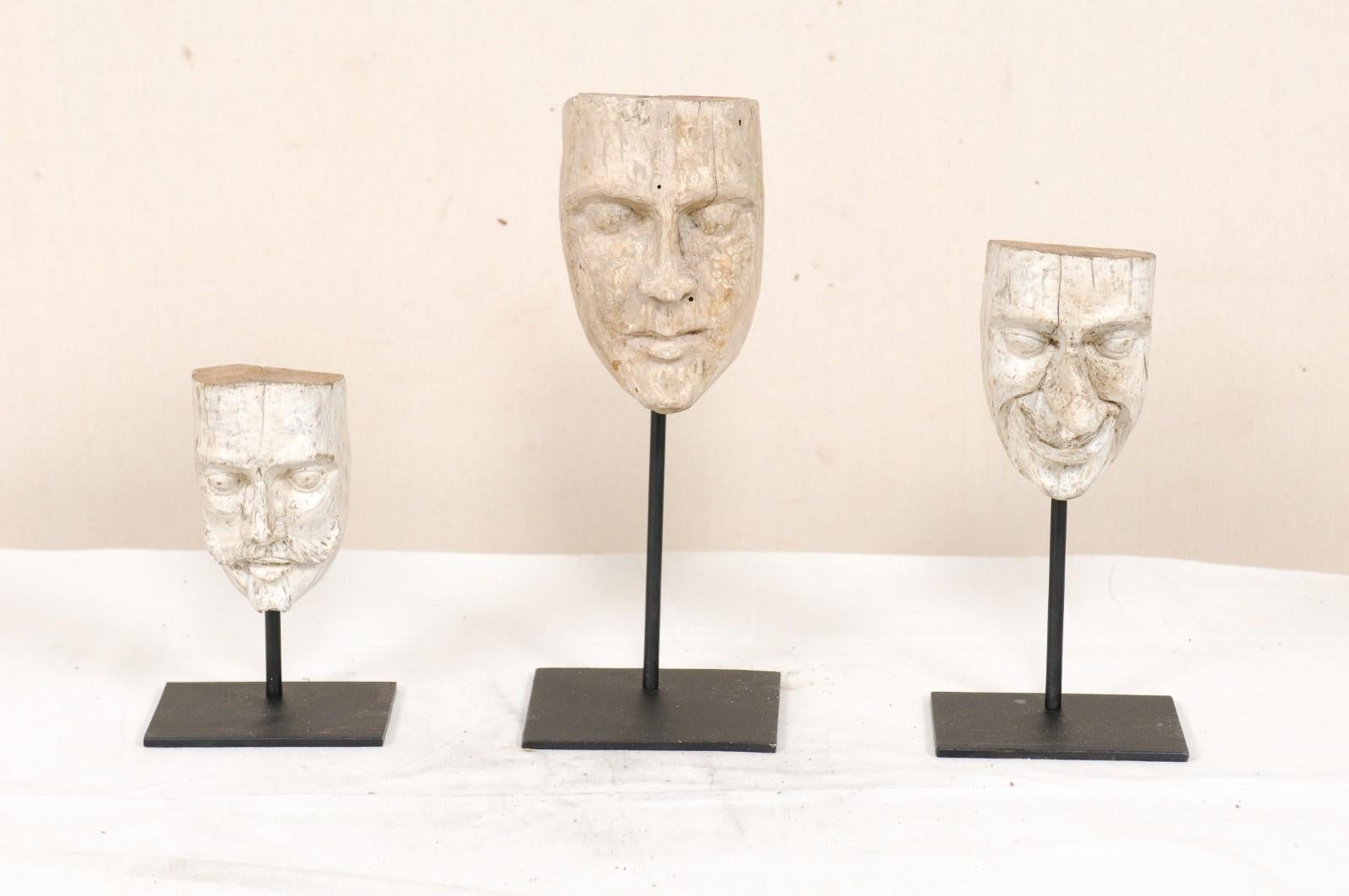 A set of three Ecuadorian wood-carved mask molds from the mid-20th century on custom stands. This collection of mask molds from Ecuador includes three individual molds, each varying in shape and size; one with an overly pronounced nose, another with