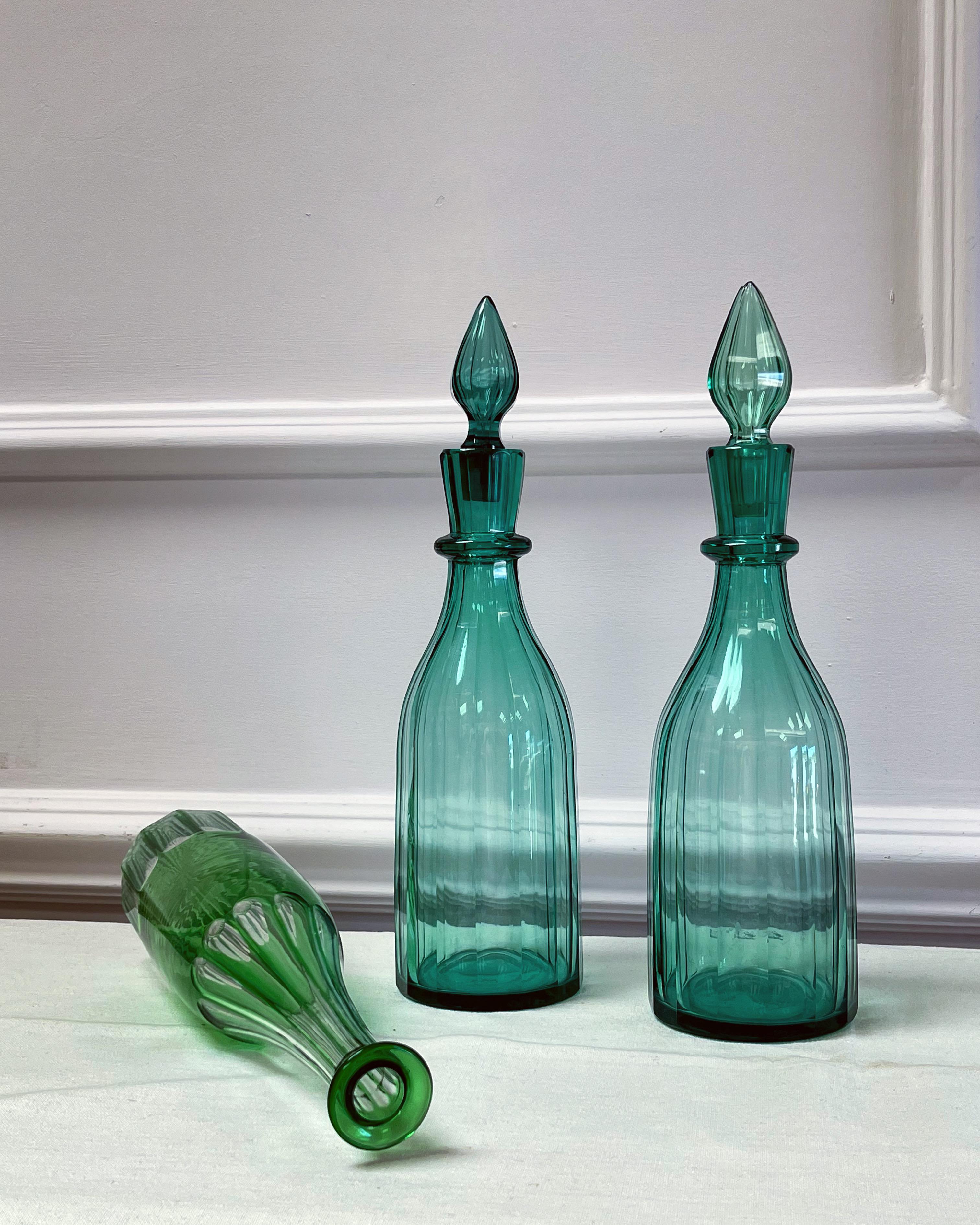 Collection de trois bouteilles d'alcool vertes, deux de style Régence et une plus tardive, variations de vert, à facettes et deux avec bouchon.

Anglais, début/milieu du XIXe siècle

H34 x L 10 cm

