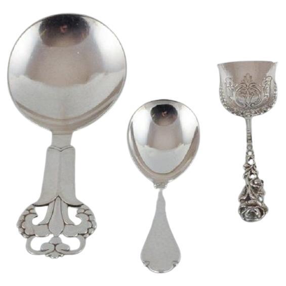 Una collezione di tre cucchiai d'argento.
