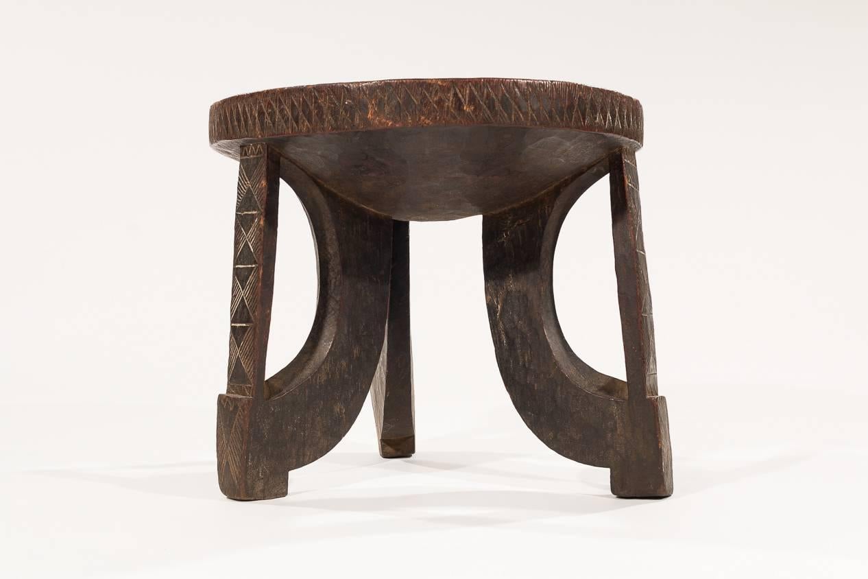 A great Ethiopian stool with unusual motifs carved on the legs. The patina is rich and the carving is highly skilled. An unusual piece.