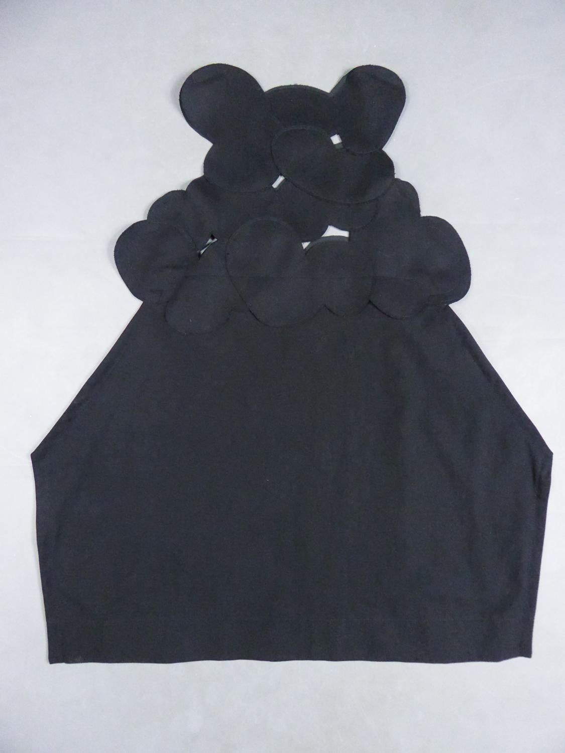 Circa 2000
France Japan

Iconic black chasuble dress by Comme des Garçons from the famous Japanese brand created by Rei Kawakubo. Master in the art of deconstruction in fashion, Junya Watanabe presents here an architectural and asymmetrical dress