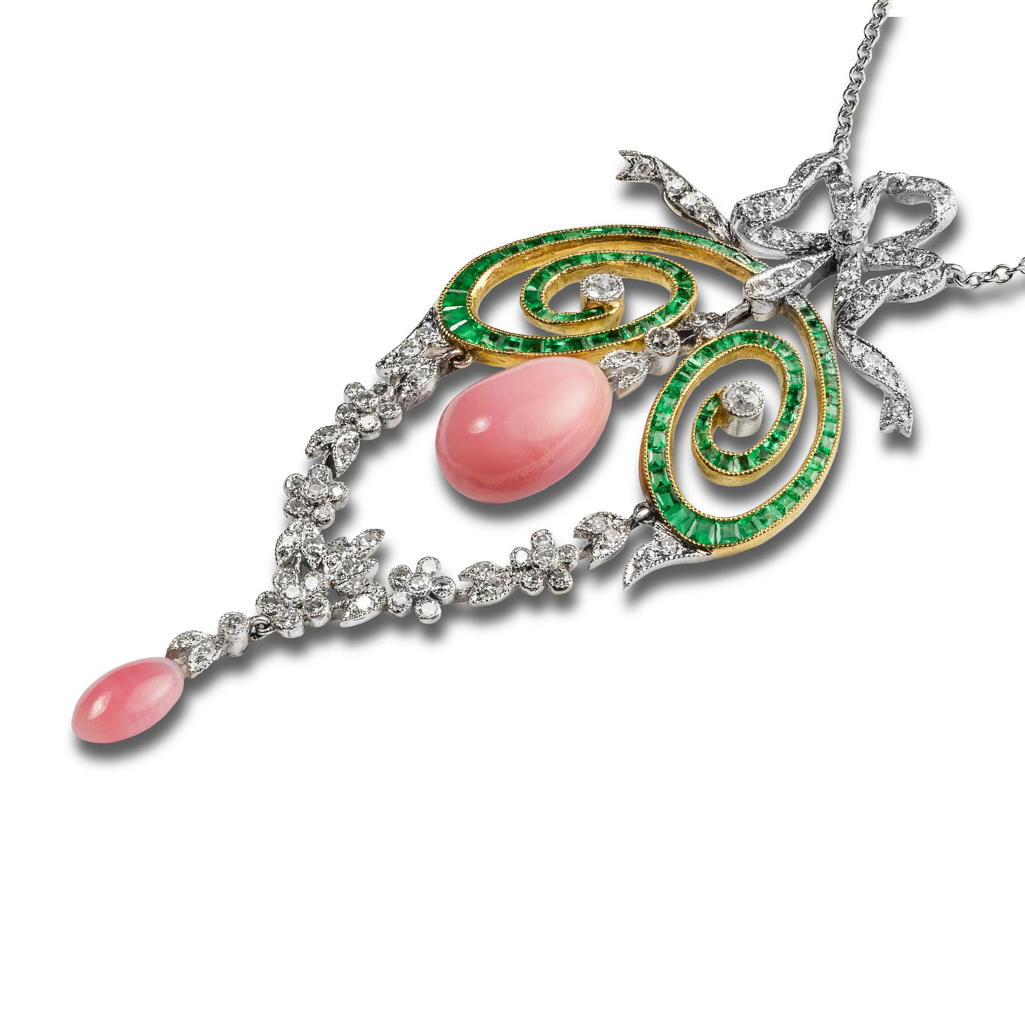 An Edwardian conch pearl, emerald and diamond pendant with later embellishments, the pear-shaped conch peal, measuring approximately 11.0 x 7.1mm, suspended by a diamond-set run between two calibre-cut emerald-set openwork scrolls, beneath a later
