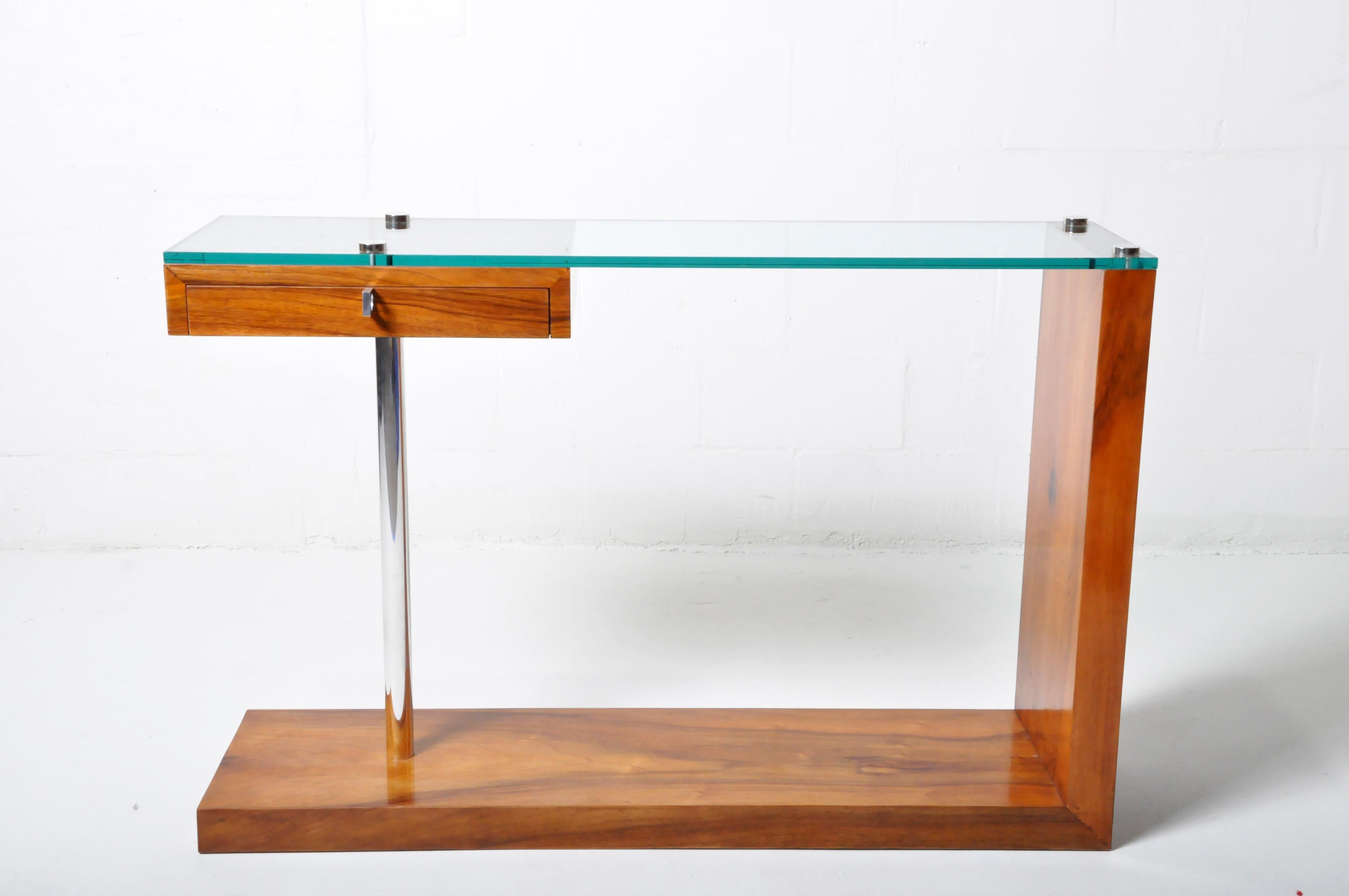 A Hungarian Mid-Century Modern console table with walnut veneer, a chrome leg and a glass top. Hungarian furniture from the 1970's and through the socialist period closely tracked Western European designs but with distinctive elements, such as the