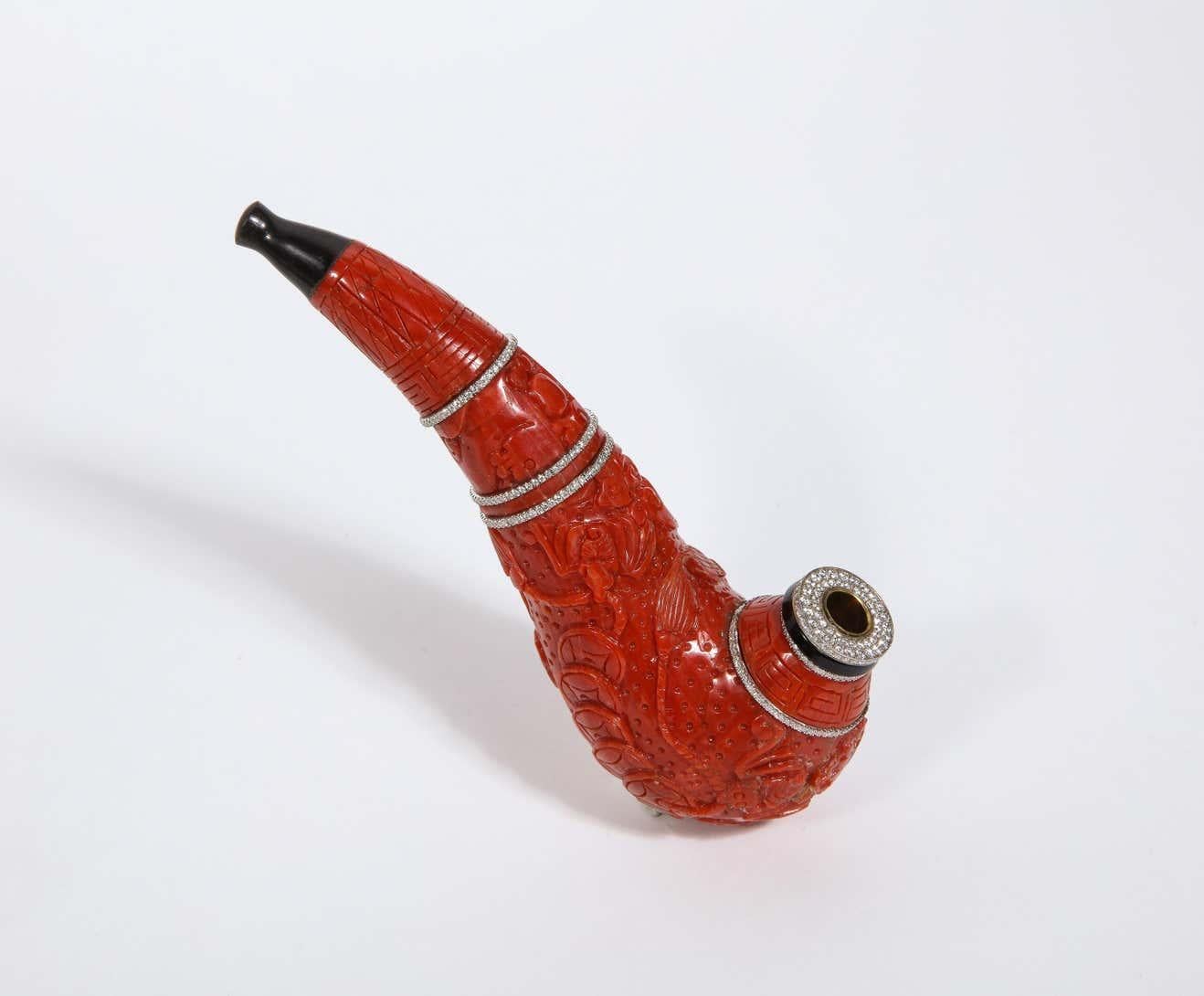 A Contemporary Coral, 18K Gold, Diamonds, and Onyx Pipe.  


The carved coral pipe engraved with Chinese ornaments enhanced with brilliant-cut pave diamonds and onyx terminal, with an ebony mouth piece.  

For a nearly identical piece, see Christies