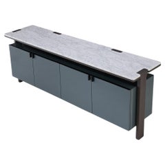 Una credenza laccata contemporanea con piano in marmo e accenti in metallo