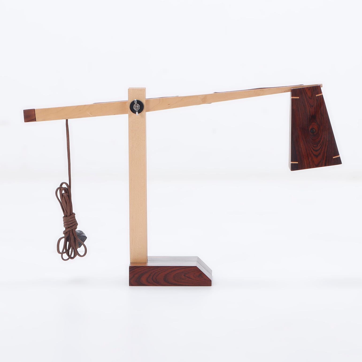 A contemporary studio made rosewood table lamp having adjustable arm.