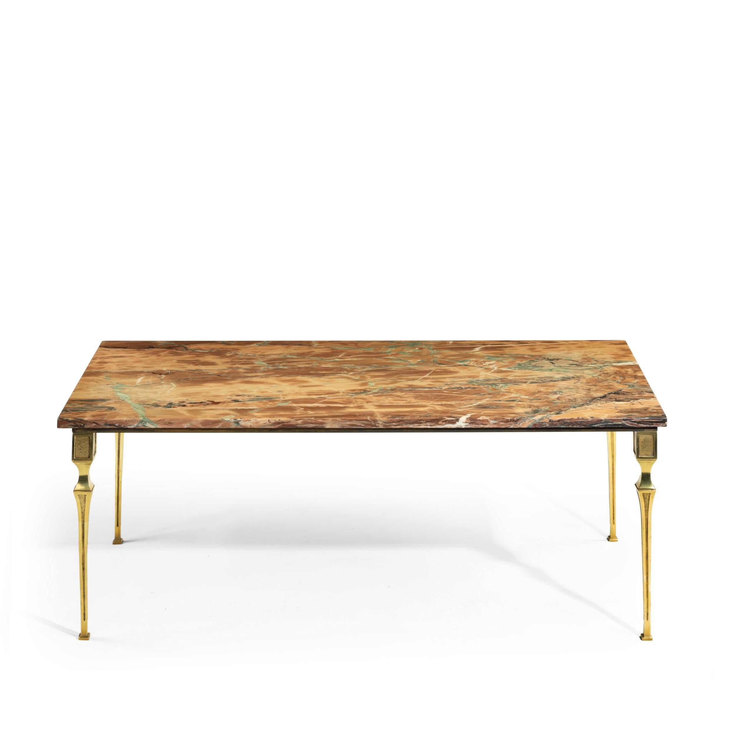 A Continental brass marble-topped coffee table, of rectangular form with a pinkish marble top raised upon four waisted and sharply tapering square section legs, decorated with stippled panels. Circa 1930.