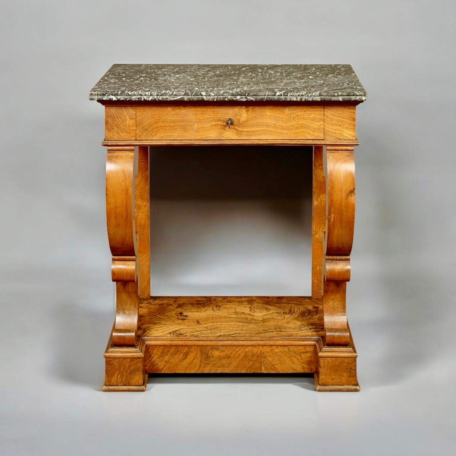 An Elegant Continental Marble-Topped Console Table, Circa 1850. The table has particularly nice proportions and features beautiful ash veneers.

The beautifully figured marble top, with an array of greyish shades and contrasting whites, is finished