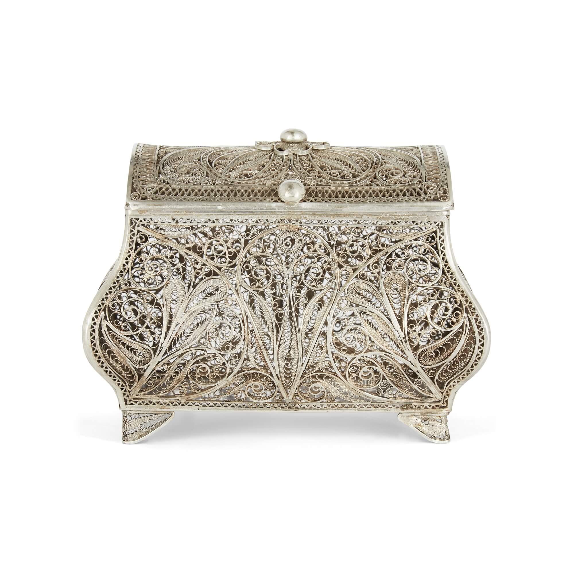 A continental silver filigree decorative flower box
Continental, Early 20th Century
10cm high x 11cm wide x 7cm deep.

This delicate and charming piece, crafted from silver filigree, is as much a jewel in its own right as it is a box for