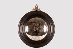 A convex mirror, frame in ebonized wood and bronze, Italy, late 19th century.