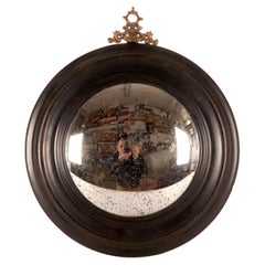 A convex mirror, frame in ebonized wood and bronze, Italy, late 19th century.