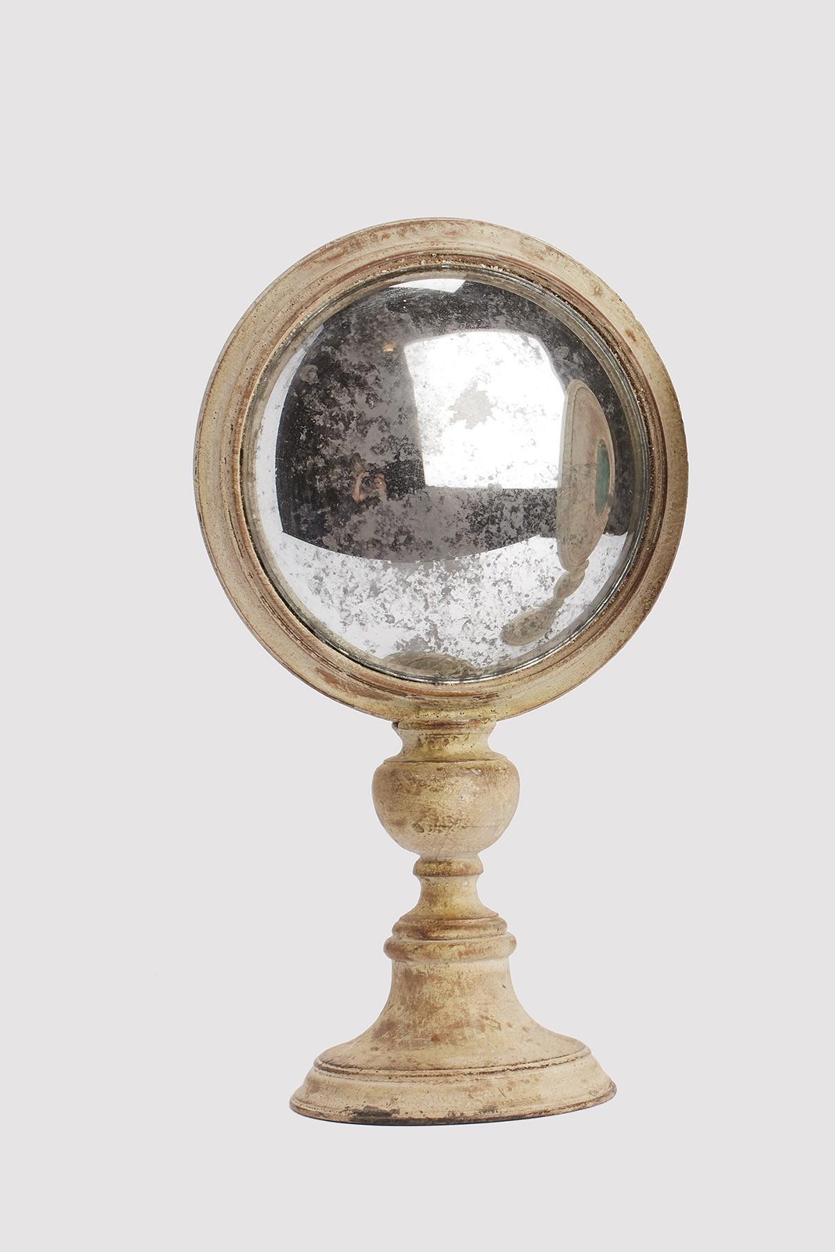 Ein runder gewölbter Wunderkammer-Spiegel mit weißem Holzrahmen, montiert auf einem runden weißen Holzsockel. Auf der Rückseite des Rahmens befindet sich ein runder Malachitstein. Italien um 1870.