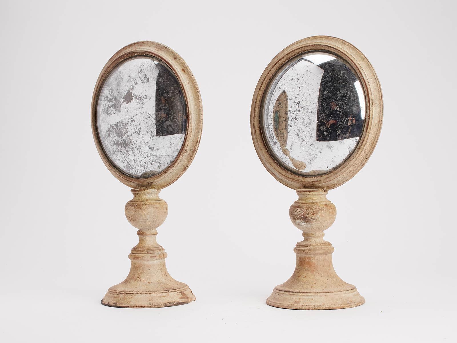 A couple of Wunderkammer round curved mirrors with white wooden frames mounted over white wooden round bases. On the rear of the frame, there is one round malachite stone, Italy, circa 1870.