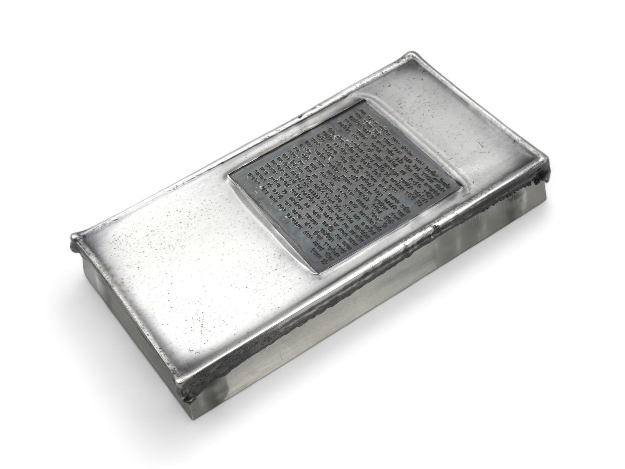 Una custodia per Mezuzah in rame e argento realizzata da Stanley Lechtzin nel 1983.

Stanley Lechtzin (1936-) Stanley Lechtzin, nato a Detroit, è il fondatore e presidente del programma di metalli/gioielli presso la Tyler School of Art della Temple
