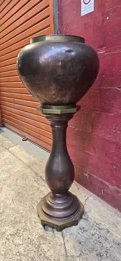 A copper pedestal vas