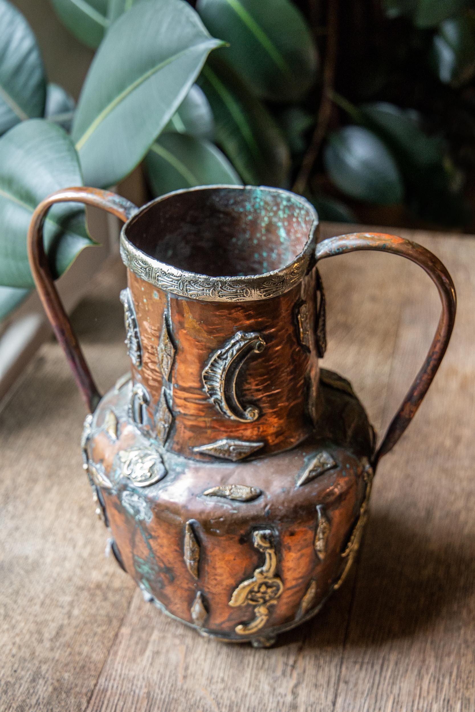 Distinctive beautiful form, artisan in feel - with brazened decorative symbols and ornamentation showing signs of aged verdigris. The brass overlaid lip with detailed pattern. 

 