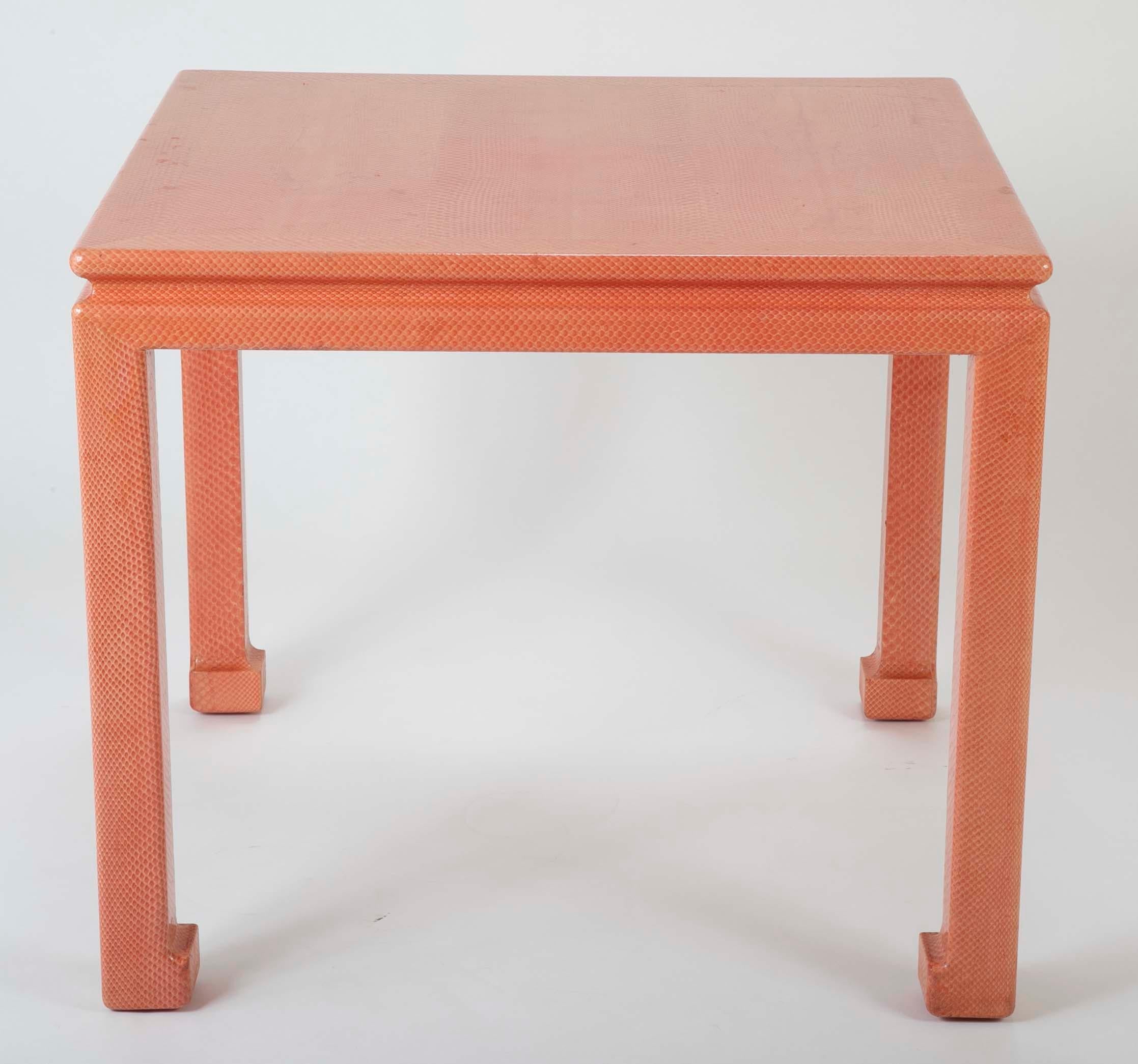A Karl Springer games table with leather label on underside. Covered in coral colored snakeskin.
