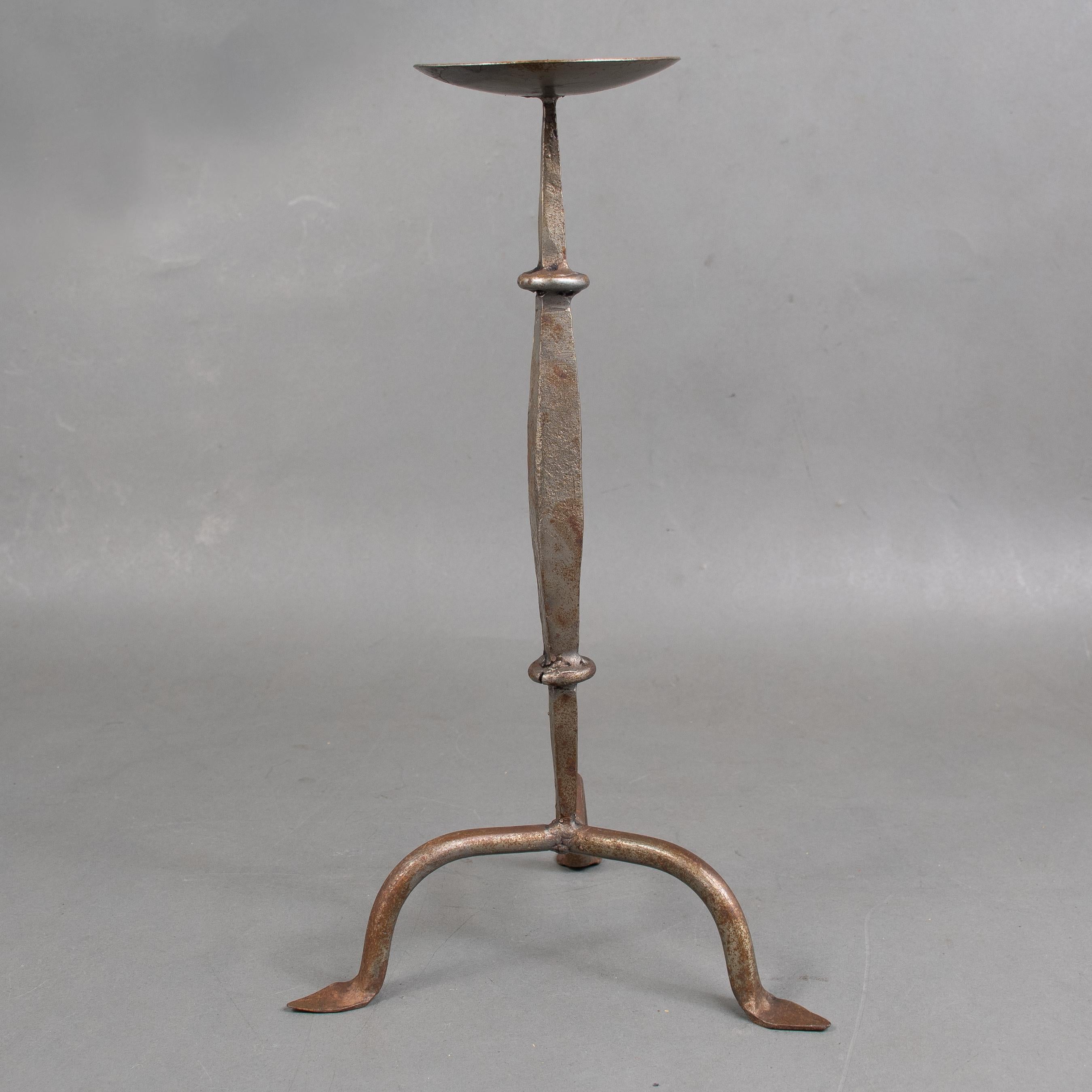 Candelero de hierro forjado a mano de la Escuela de Artes y Oficios de Cotswold, sobre tres pies almohadillados.