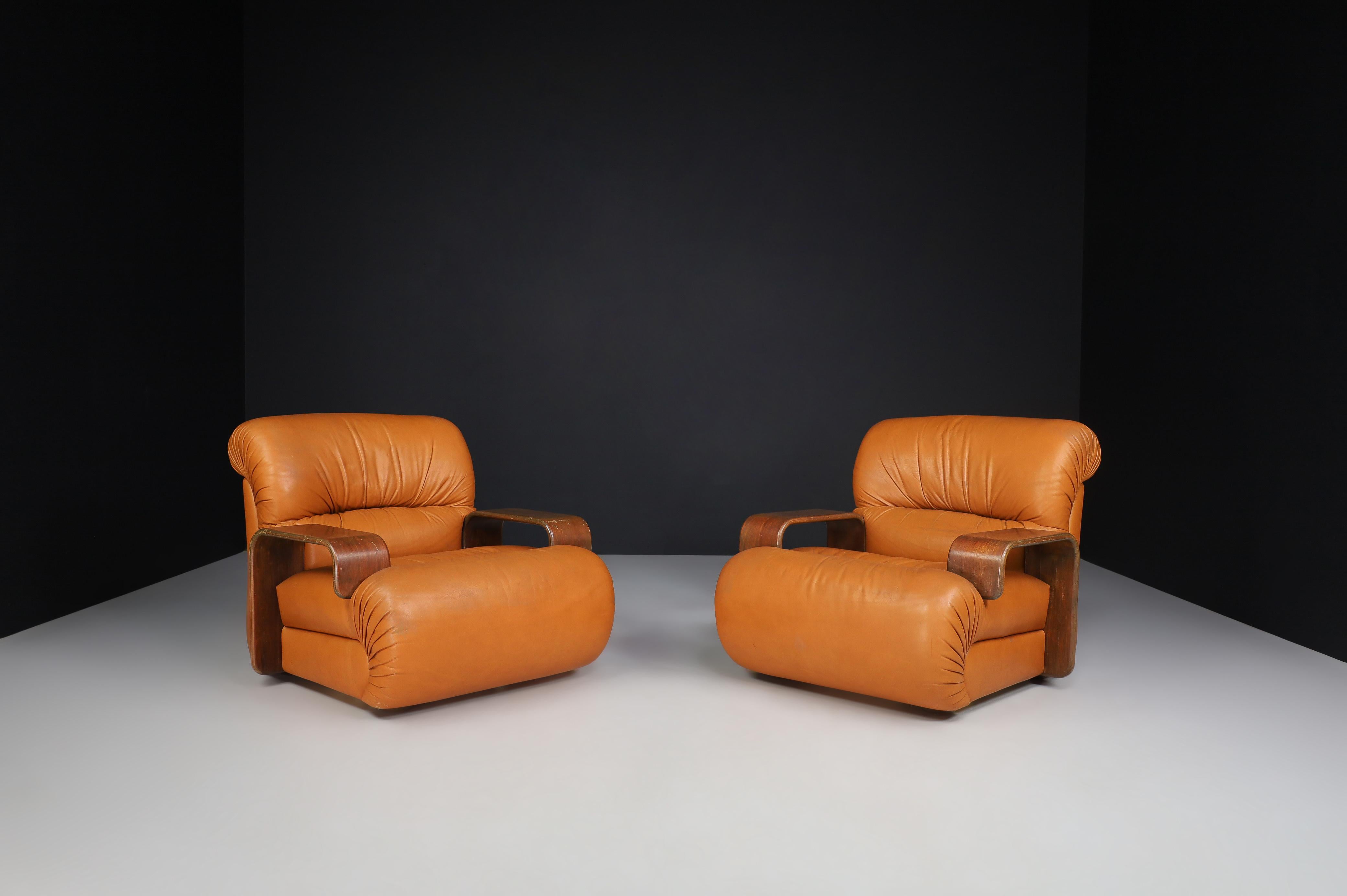 Lounge Chairs in Bentwood and Cognac Leather, Italy 1970 

A couple of big, stylish lounge armchairs that feature round lines and shapes invite you to take a seat and relax—designed and produced in Italy in the 1970s. Generously proportioned brown