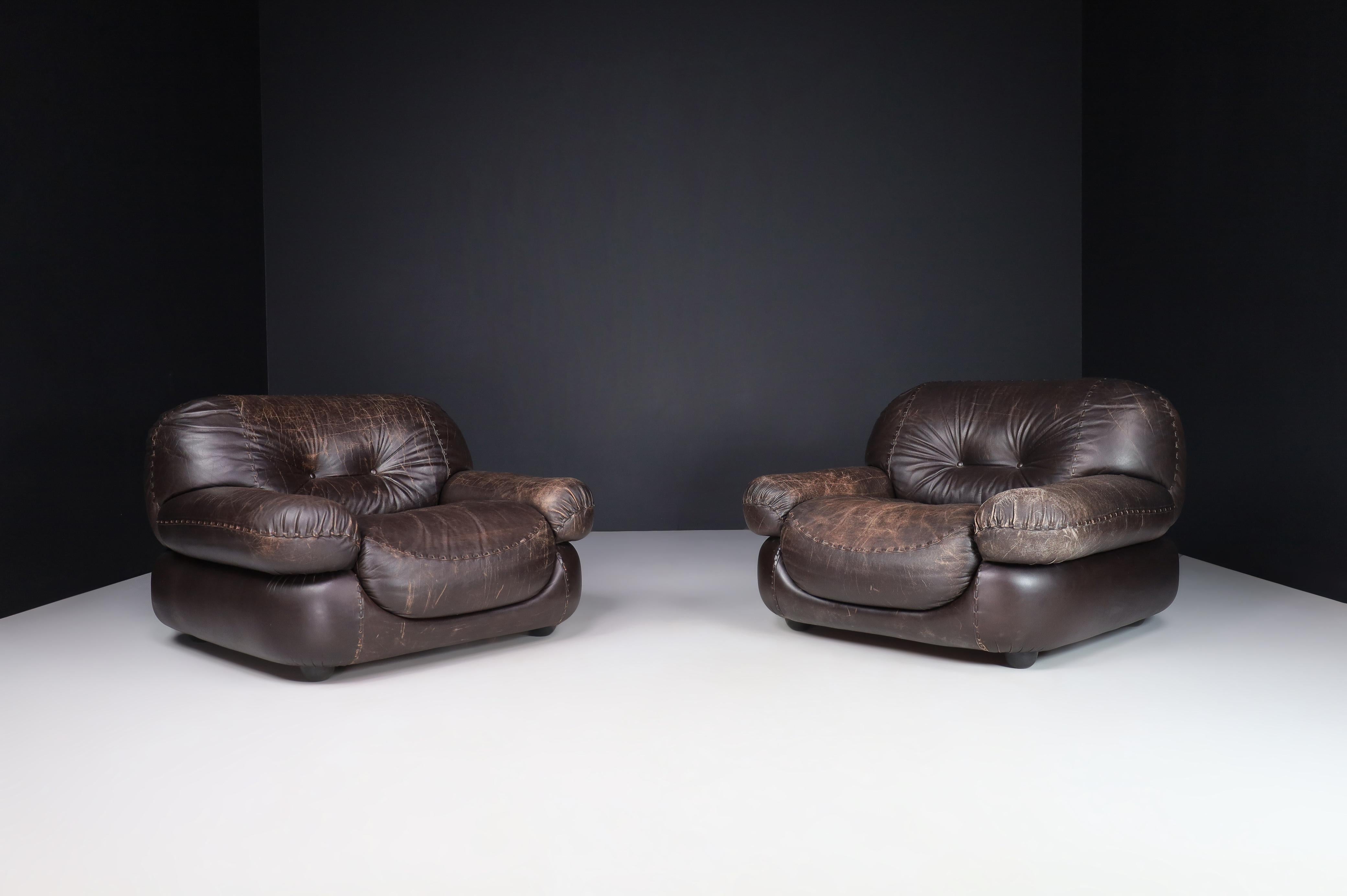 A couple of Lounge chairs in Patinated Brown Leather by Sapporo for Mobil Girgi, Italy 1970

A pair of lounge chairs in Patinated brown leather by Sapporo for Mobil Girgi, Italy, in the 1970s. A couple of big, fluffy, stylish lounge armchairs that