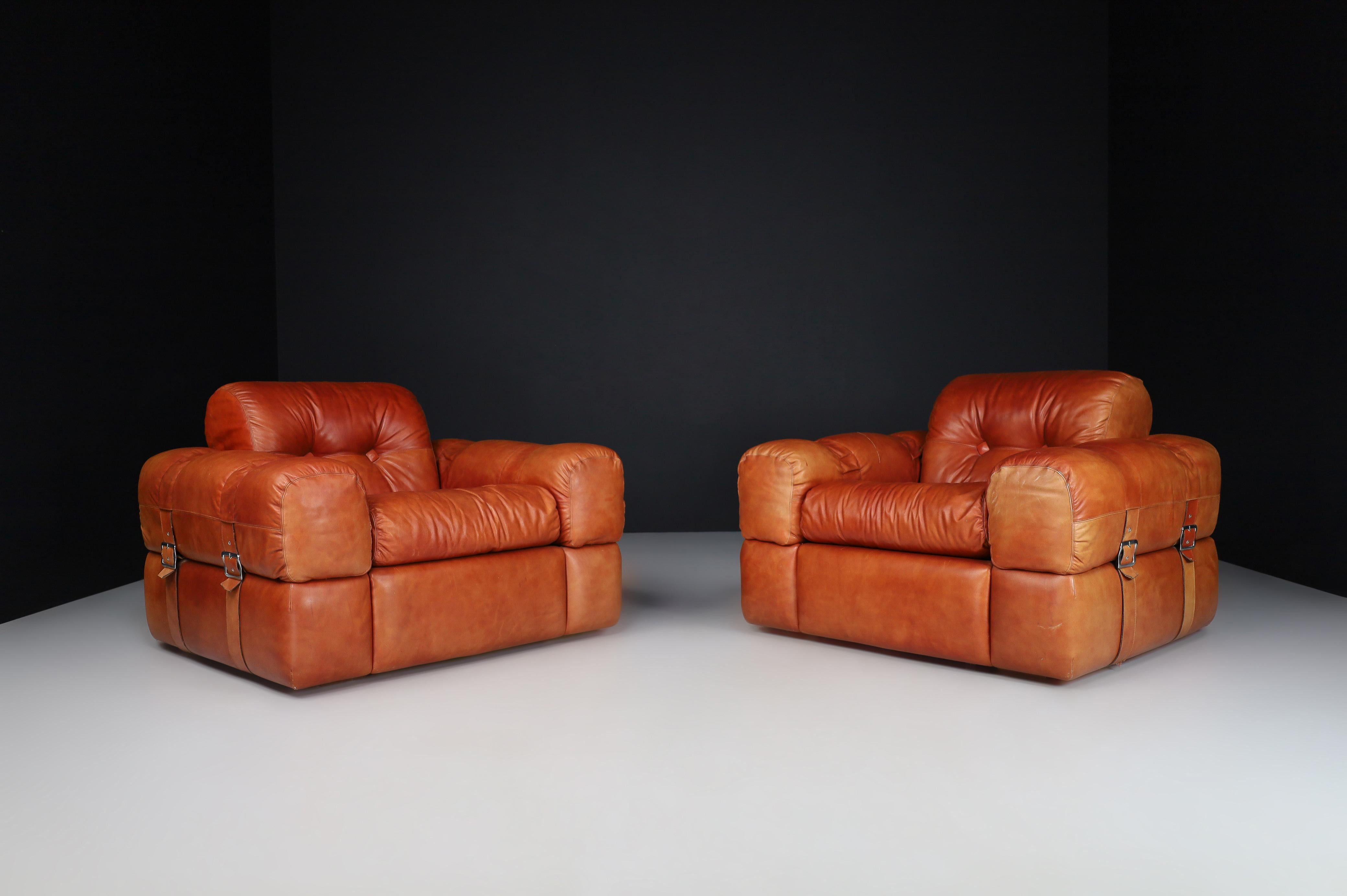 A couple of Lounge Chairs in Patinated Cognac Leather, Italy 1970

A couple of oversized, large, modern lounge armchairs that feature straith lines and shapes invite you to take a seat and relax—designed in Italy in the 1970s. Generously