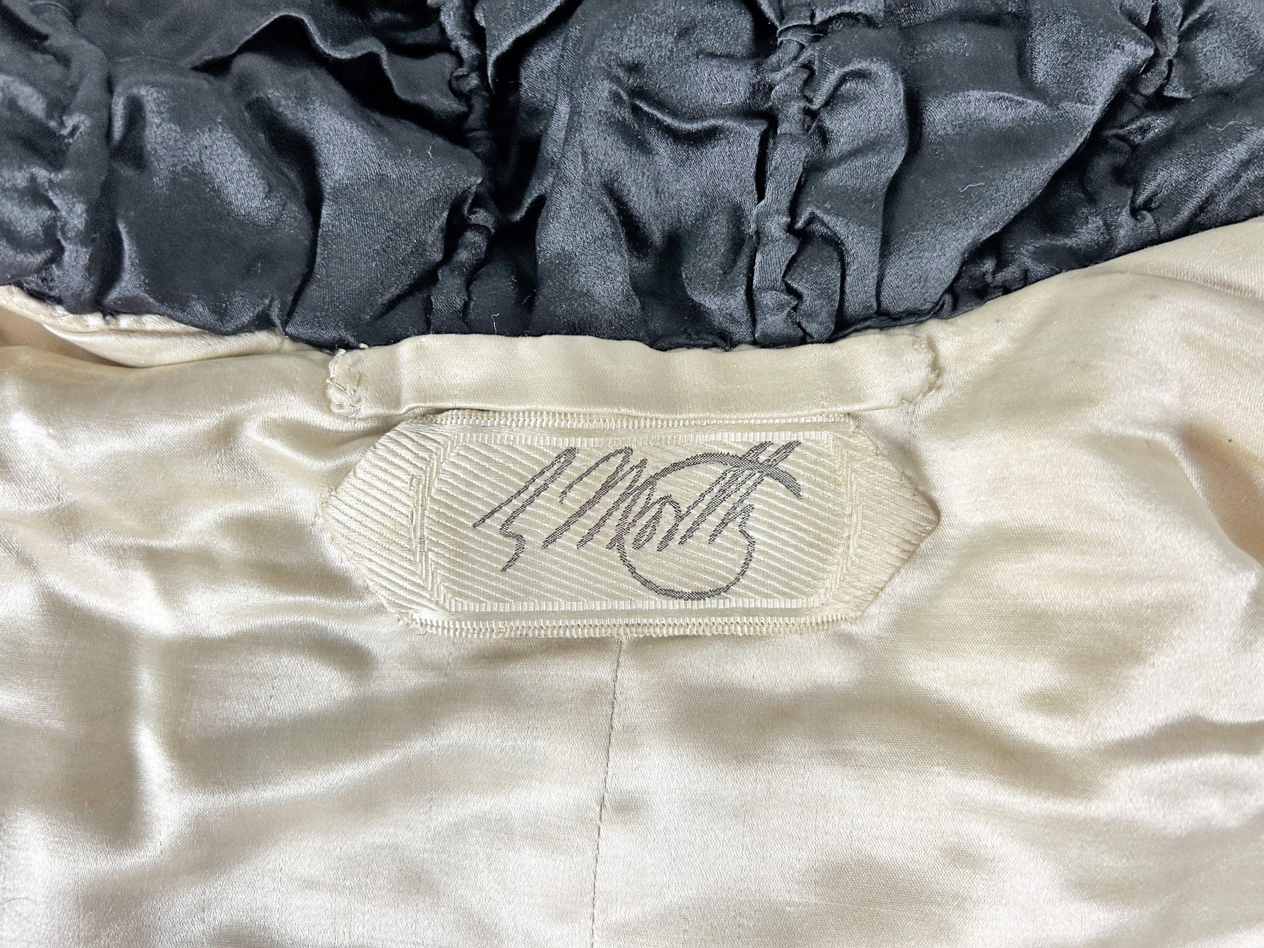 Circa 1930-1935
Parigi
Un cappotto da opera o da sera in velluto di seta nero ricamato con rose della famosa House of Worth, numerato 32812 (?), del periodo in cui Jean Charles Worth era al timone. Con una vestibilità ampia, maniche lunghe a