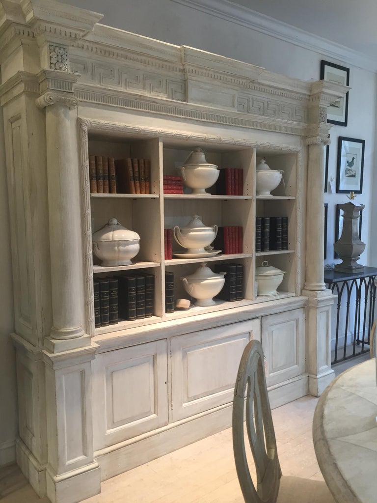 A cream painted wooden neoclassical bookcase in two sections at 1stDibs