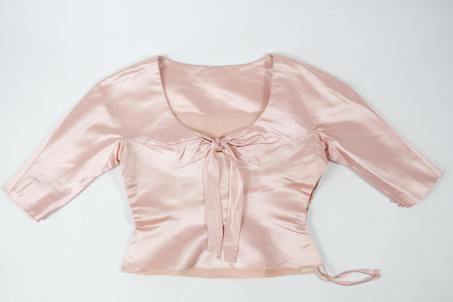 Circa 1958/1962
France
 
Majestueuse robe du soir en satin rose poudré de Cristobal Balenciaga Haute Couture numérotée 61819 et datant de 1958/1962. Robe en deux parties, bustier structuré avec manches raglan trois-quarts garnies de deux boutons.