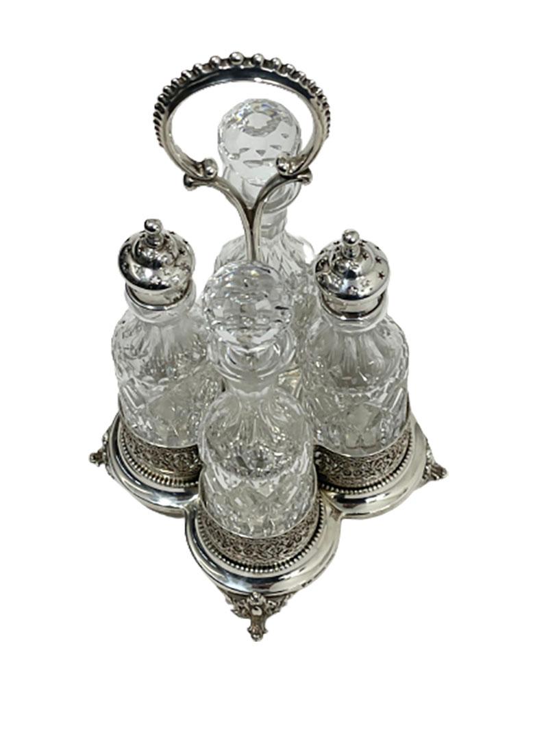A crystal with silver Cruet set by Topazio

A set of 4 crystal bottles in a base of 4 round holders with a handle in loop pattern with pearl rim 
The holders for the bottles are openwork with shell, leaf and floral motif, between 2 gadroon