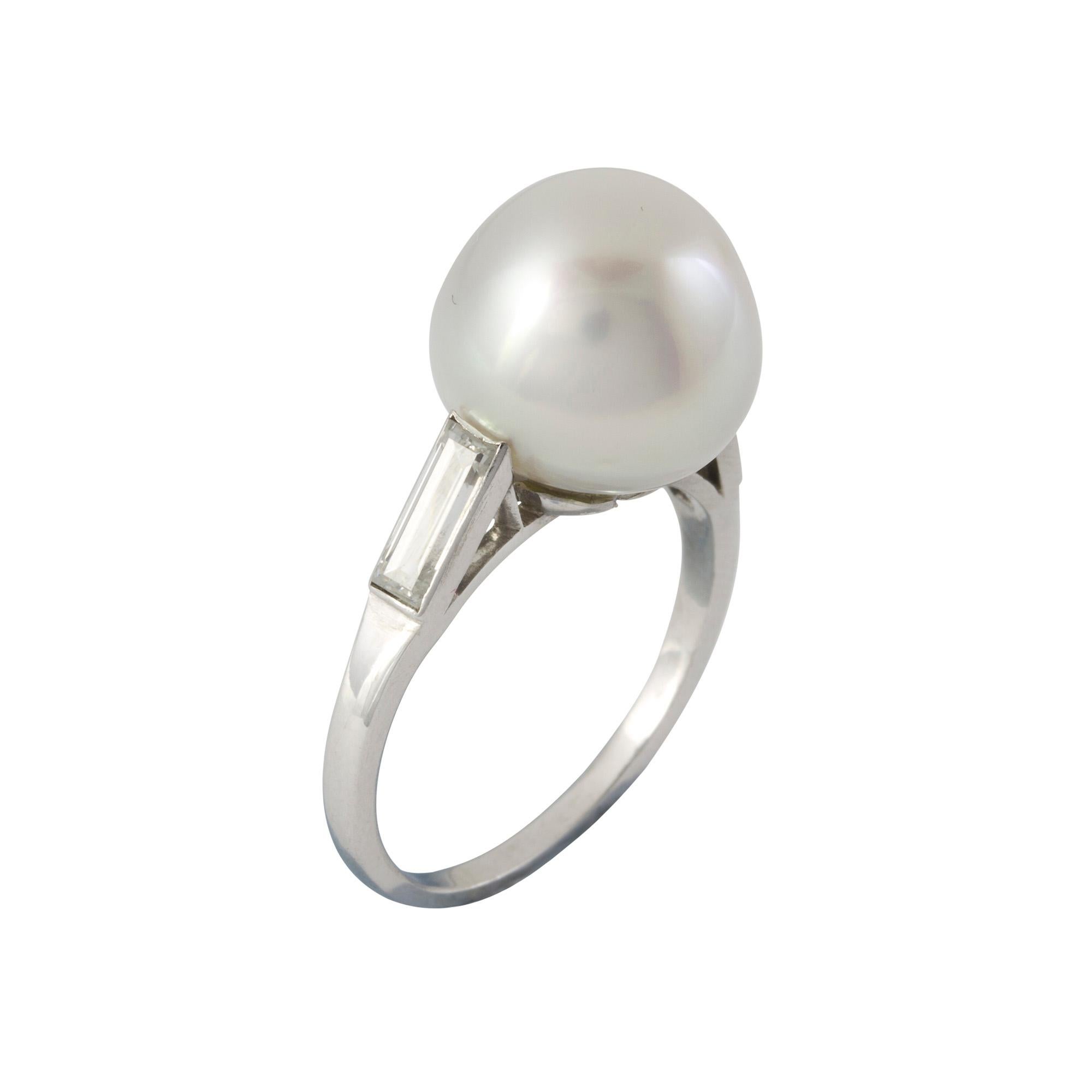 A cultured pearl and diamond ring, the cultured pearl measuring approximately 11.9x11.5 mm in diameter, set to a platinum mount with baguette-cut diamond shoulders, estimated to weigh  a total of 0.7 carats, hallmarked 900 Platinum London, head size