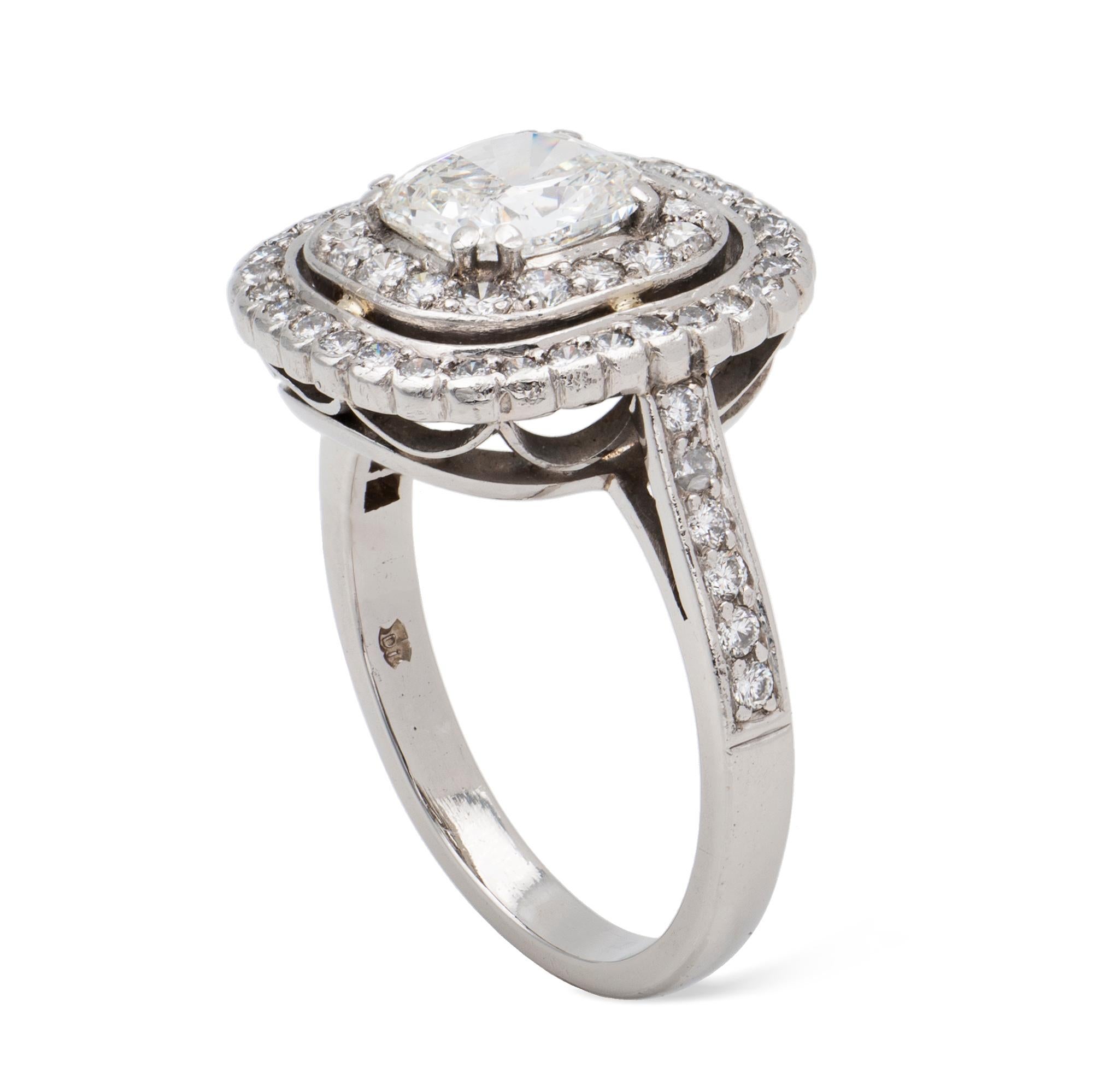 A diamond cluster ring, the cushion brilliant-cut diamond, accompanied by GIA report number 17235376, stating the diamond to weigh 1.03 carats, of G colour and VS2 clarity, four double claw-set to the centre, surrounded by double cluster with a