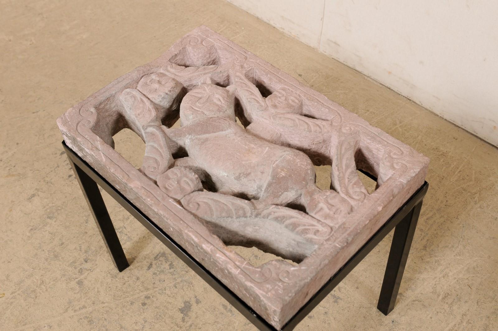 A unique side table, which has been custom fashioned with a Mexican carved-stone paver. This fun little accent table features a vintage carved-stone from Mexico, whose pierced carvings showcase a chubby cat (or gato) at center with winged cherubs at