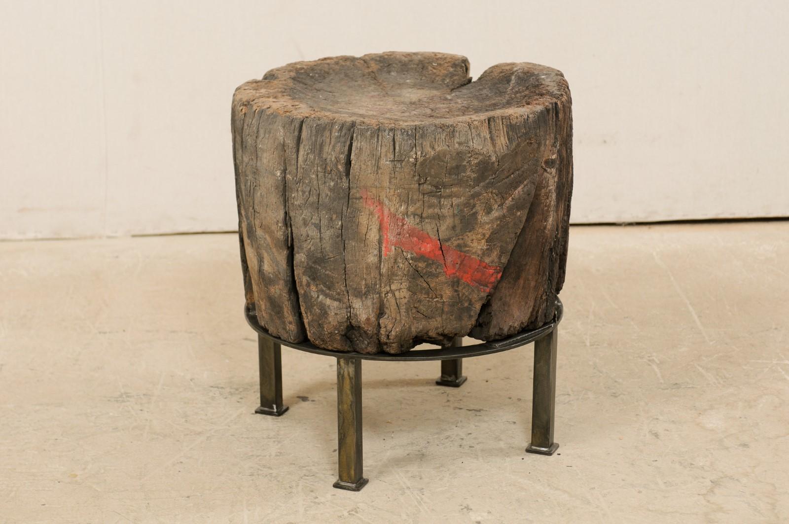 This modern meets old world designed side table has been custom fashioned with a European 19th century chopping block top mounted onto a contemporary iron base. This unique and one-of-a-kind piece has been created with an intriguing mix of rustic