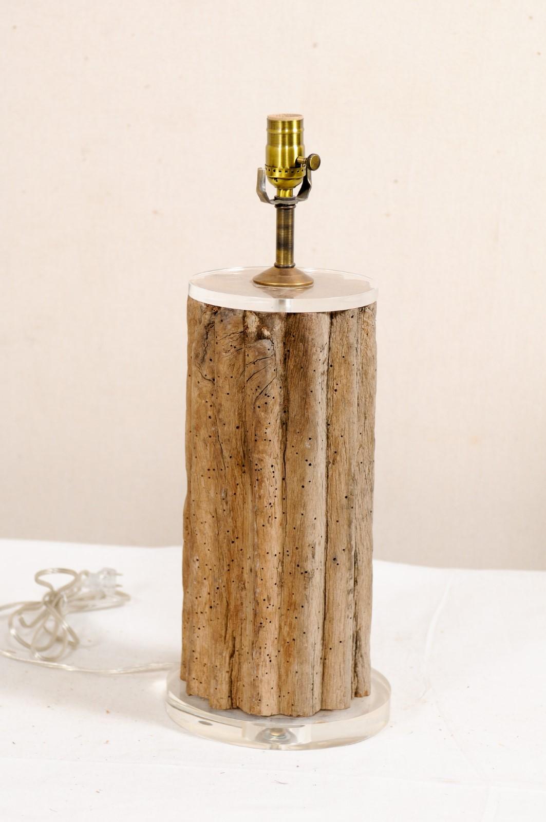 A custom table lamp with a 19th century French wine grinding post and Lucite base. This unique table lamp has been custom fashioned from a cut section of a 19th century wooden grinding post from France, now acting as it's column body, topped with a