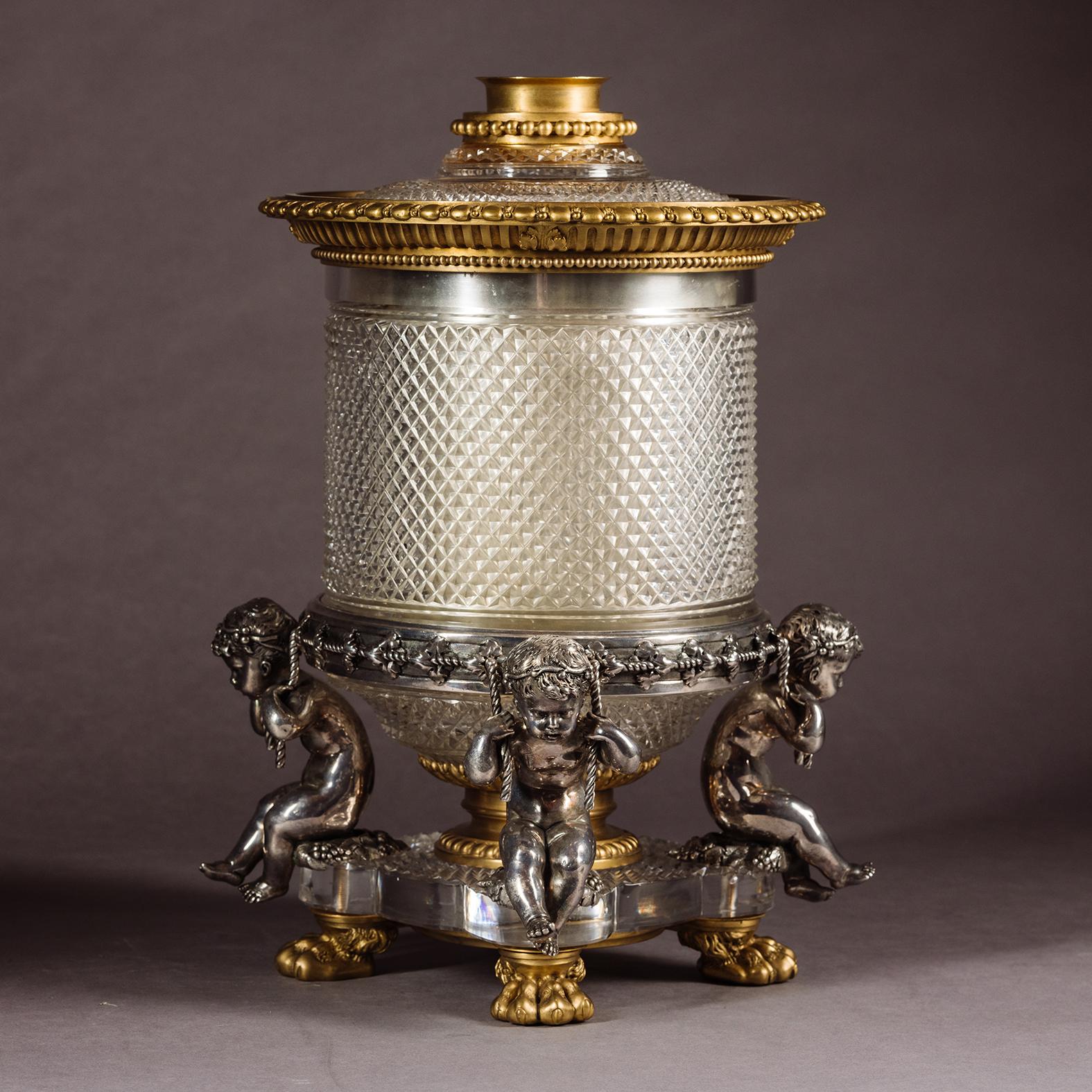 A Rare Cut-Crystal Glass, Gilt and Silvered Bronze Wine Cooler, By Cristalleries de Baccarat, Paris.

The removable lid with an central aperture to allow the bottle neck to protrude. The body with a removable nickel-plated liner around which there
