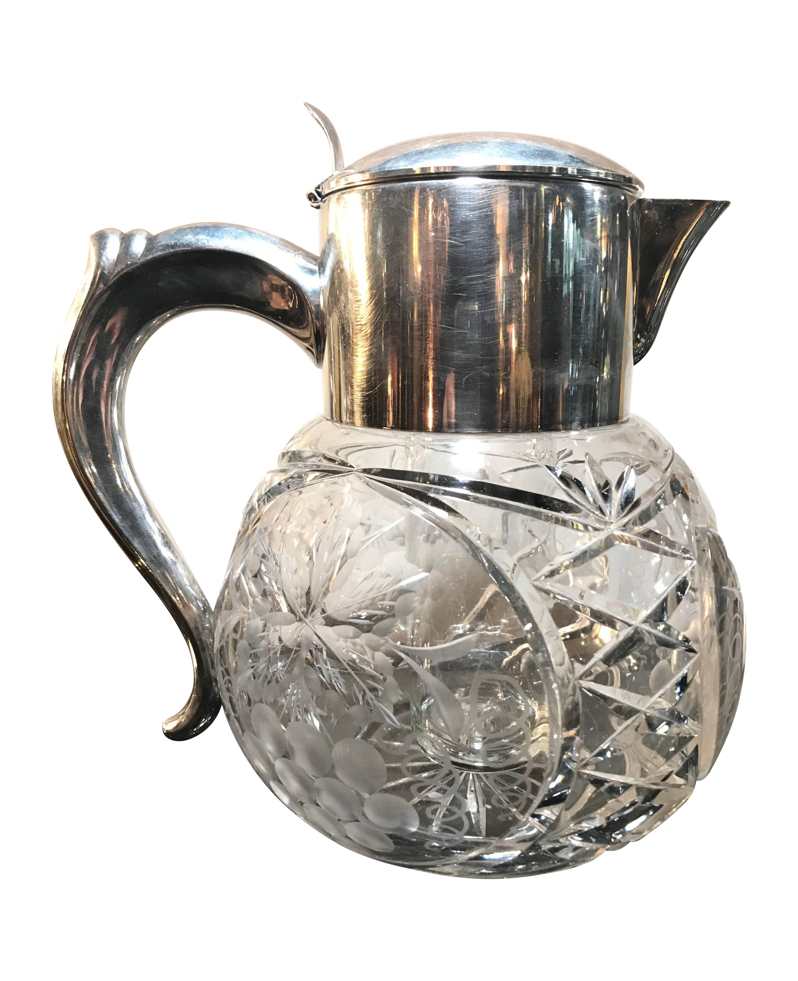 A beautiful cut-glass lemonade or cocktail jug, decorated with grapes and leaves, with hall marked silver plated handle and hinged lid, that opens to remove glass ice compartment that chills, but doesn't dilute the drink. Beautiful quality piece