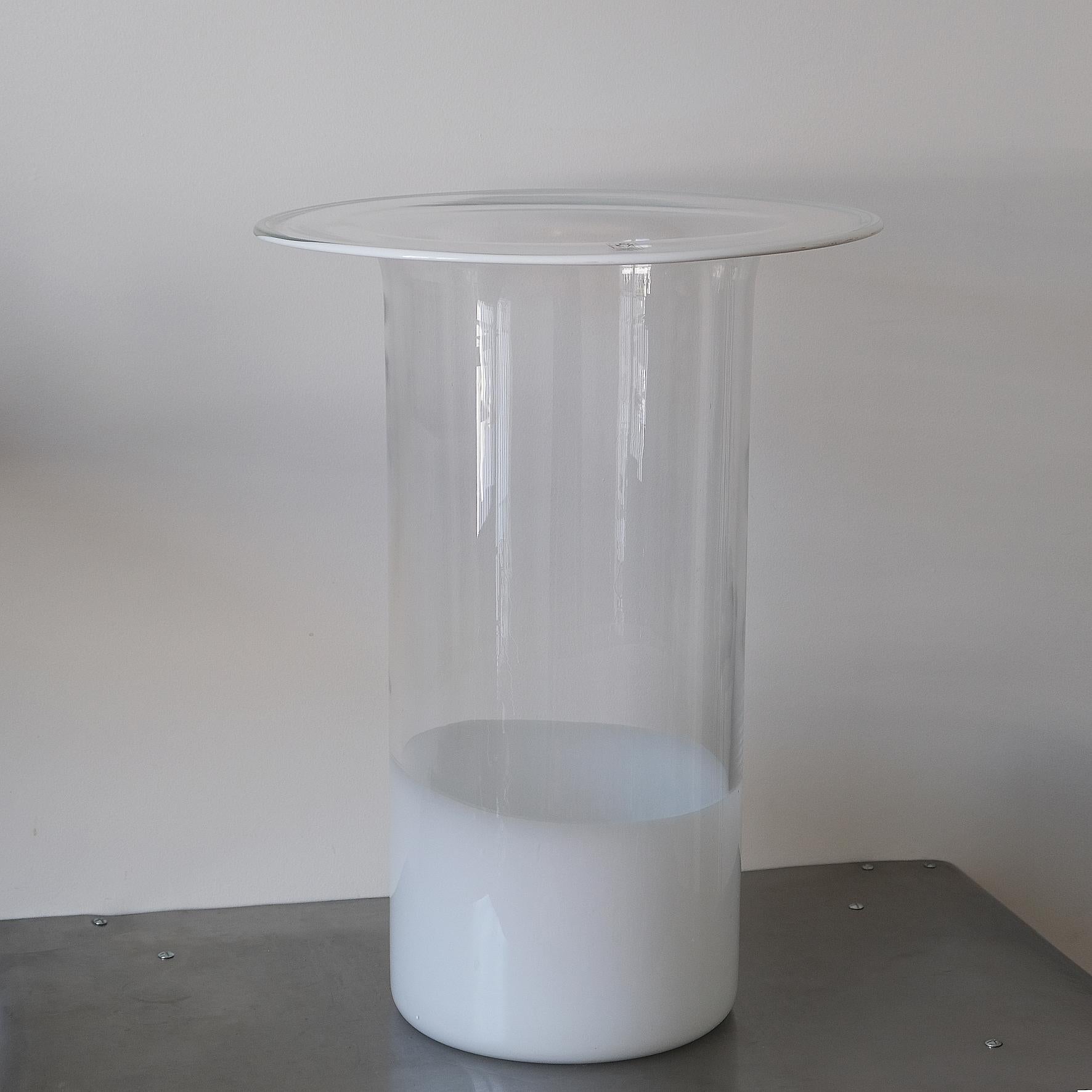 Renato Toso

Chiclos

A beautiful and tall blown glass vase, the white and transparent cylinder body 
terminated with a spreading circular rim.
Produced by Leucos, Italy.
Circa 1968.

Dimensions
Height: 56.5 cm 
Diameter: 42 cm
Inside