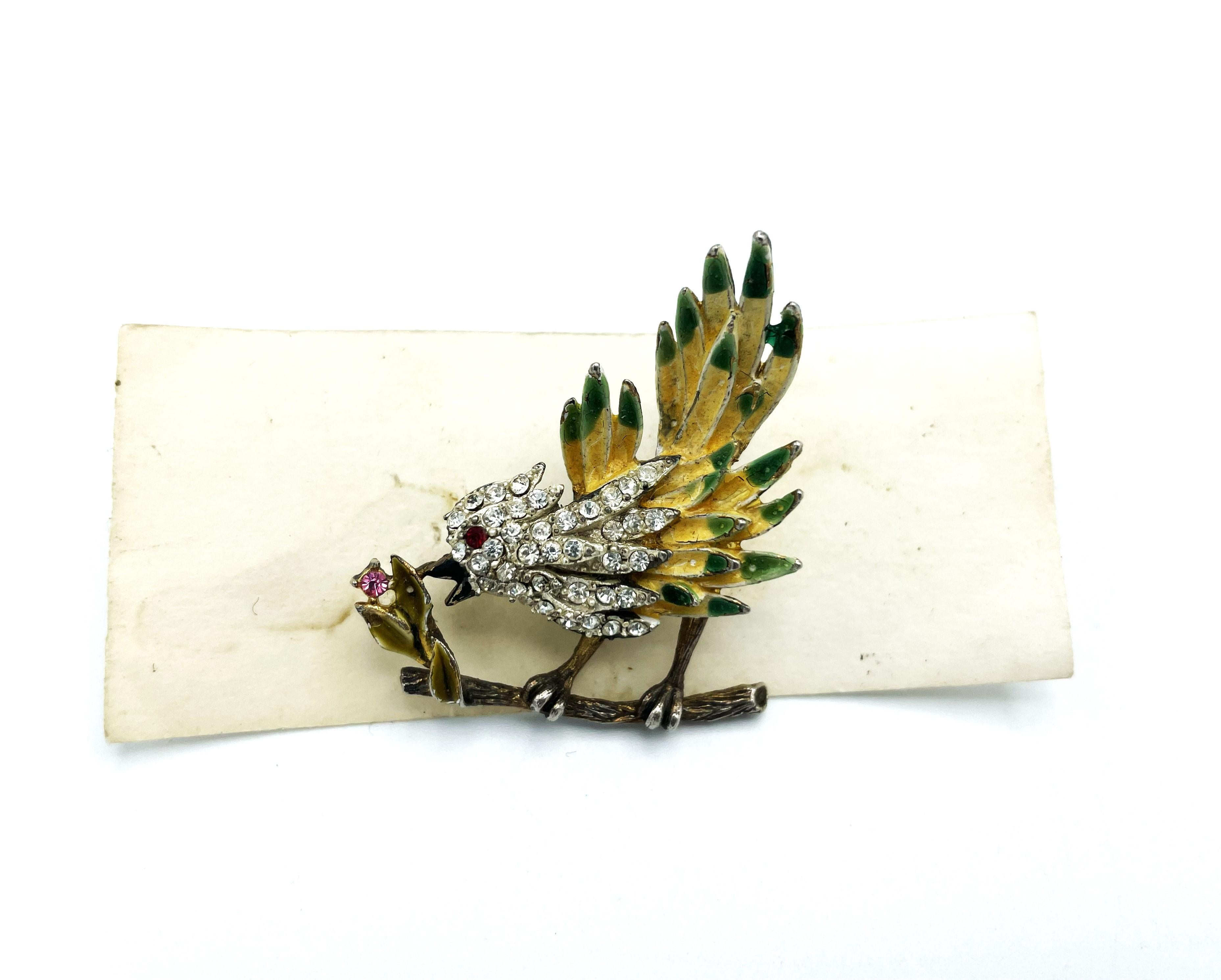A dainty little bird brooch by Kramer NY, 1950s with lots of small rhinestones and enameled sitting on a branch picking on  a tiny flower. Signed on the back of the brooch with KRAMER:
Very perfect condition for this age!
Dimensions
High  4 cm - W 3