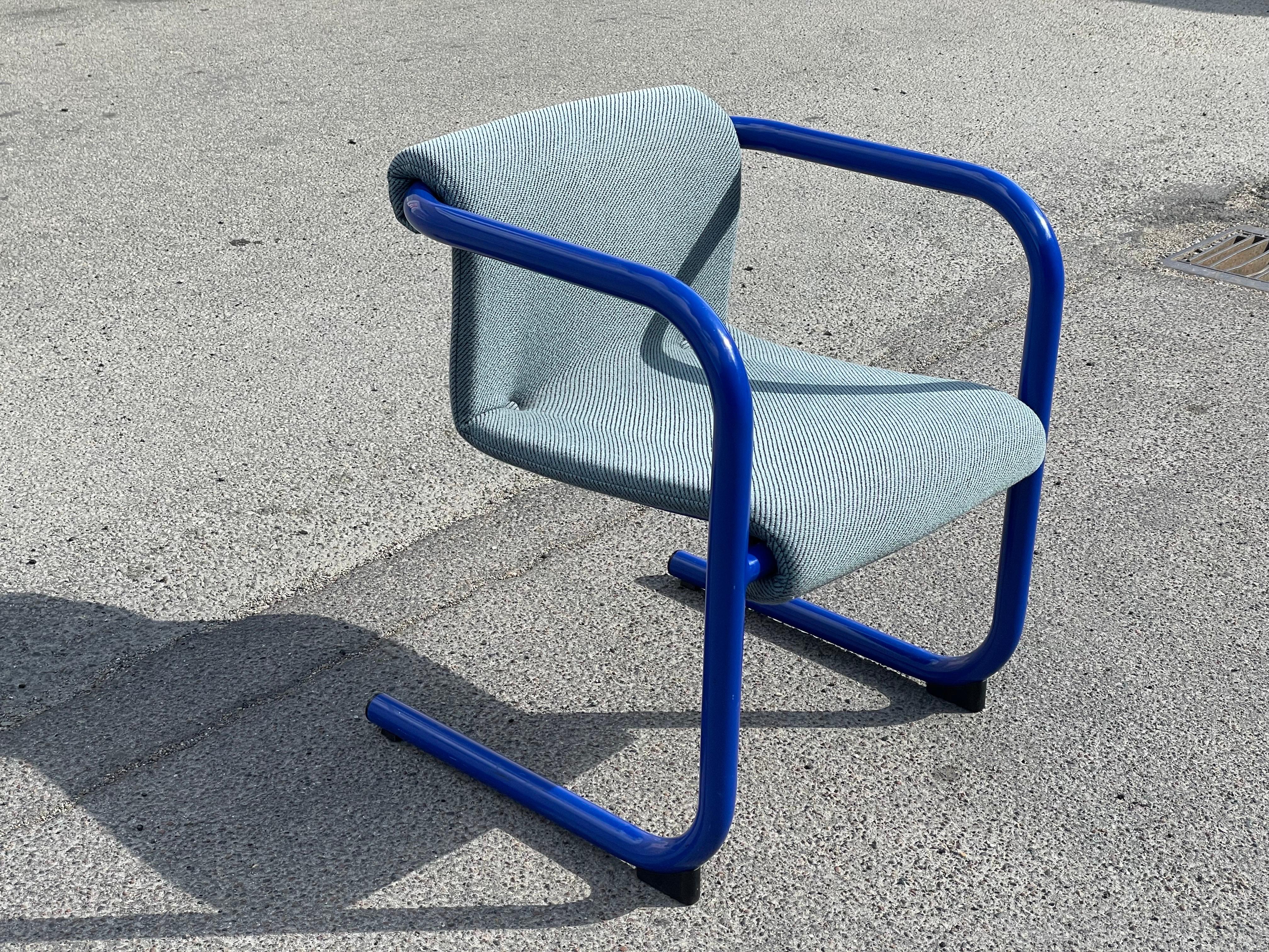 A Danish design treasure from the 1980s - the Cantilever Armchair by Knud Friis & Elmar Moltke Nielsen. This iconic blue piece showcases the perfect blend of Danish craftsmanship and contemporary aesthetics. With its sleek and innovative cantilever
