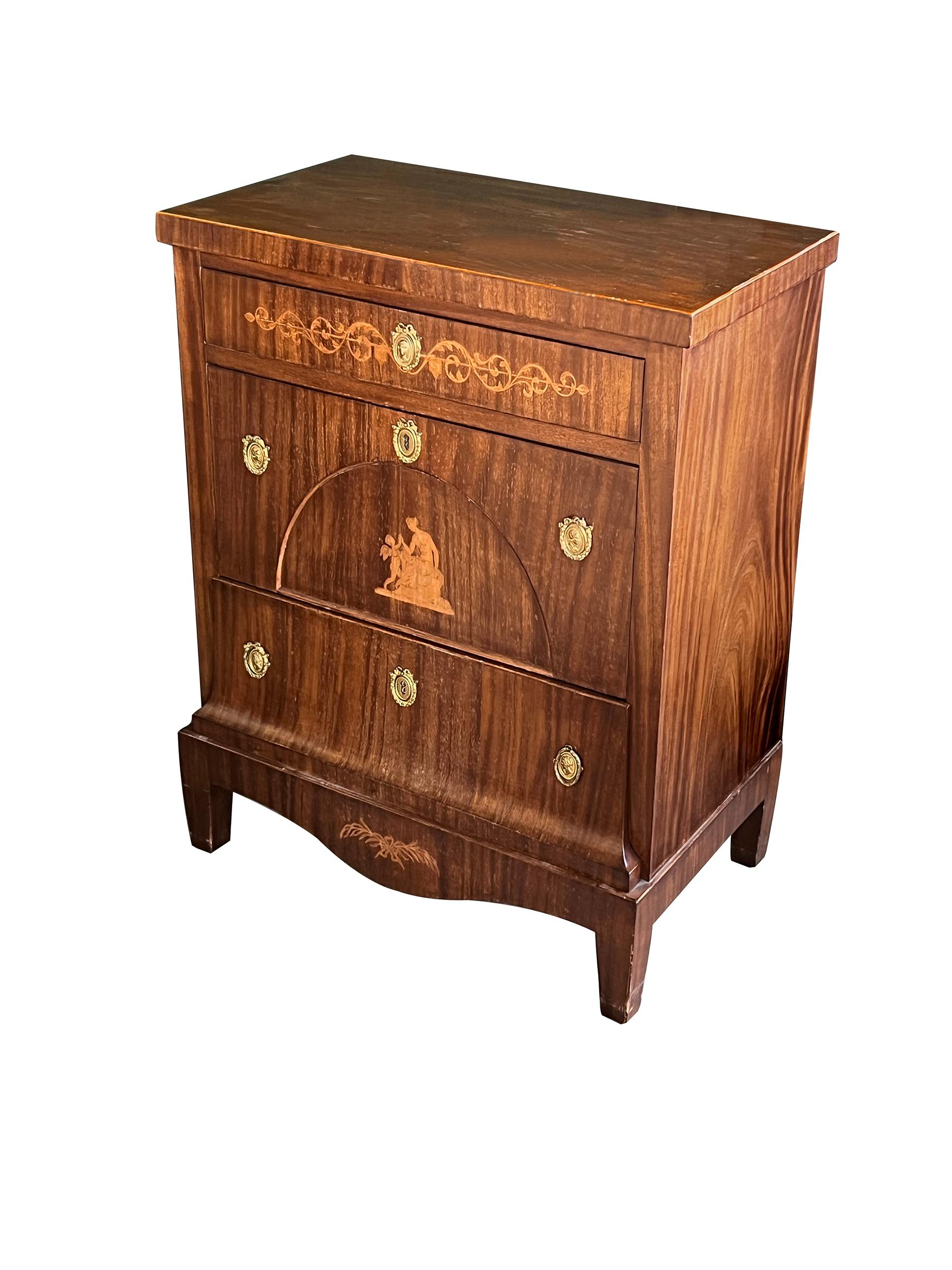 the handsome chest constructed during the Golden Age of Danish furniture (1800-1850) and composed of well-figured mahogany veneer fitted with three drawers inlaid with neoclassical decoration all over a scalloped apron and raised on tapering