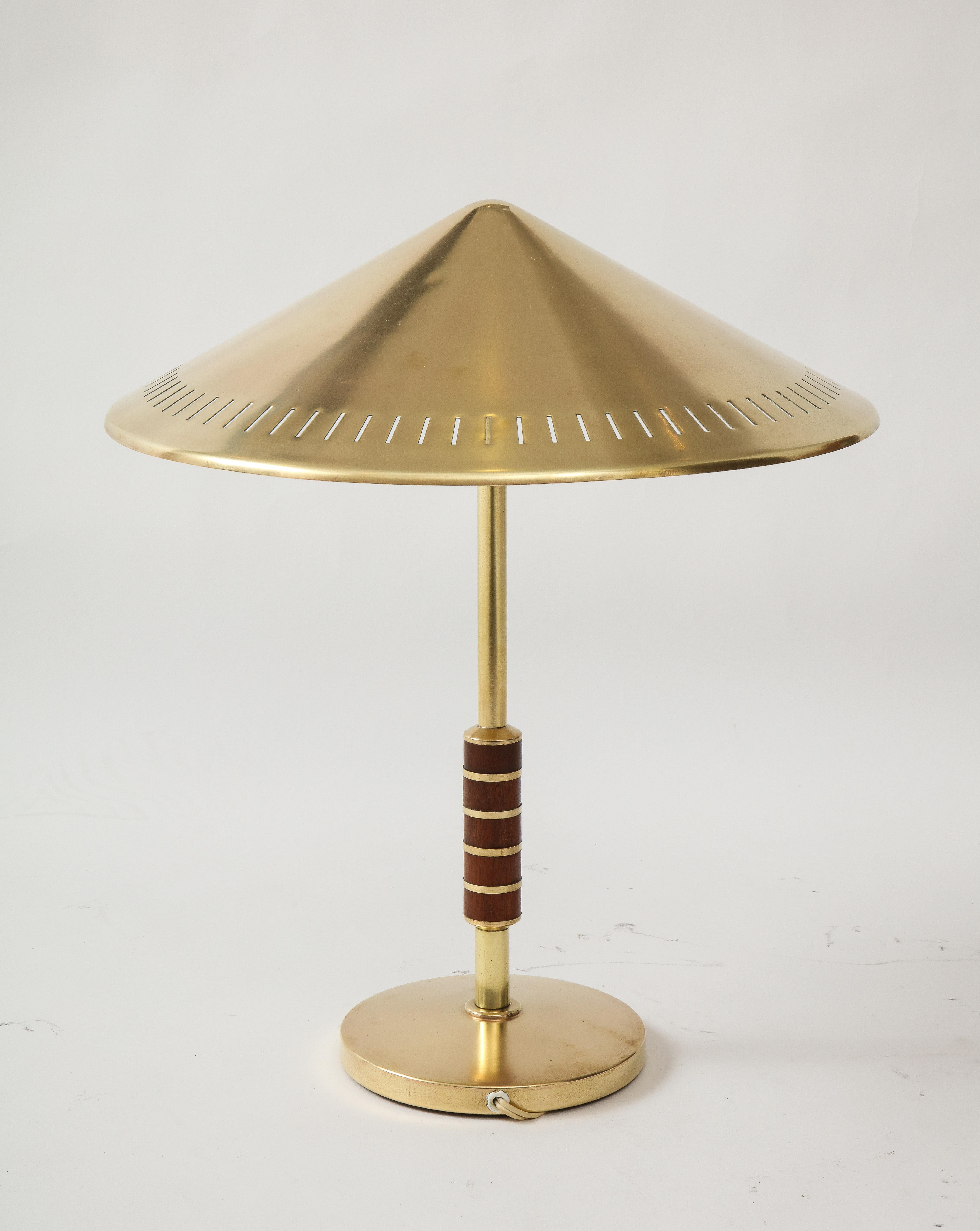A Danish brass table lamp produced by Lyfa 1956 and designed by Bent Karlby. Model B146. Solid brass cone form shade with two-lights, stem with rosewood banding. Re-wire for the US. Two 60 watt max.