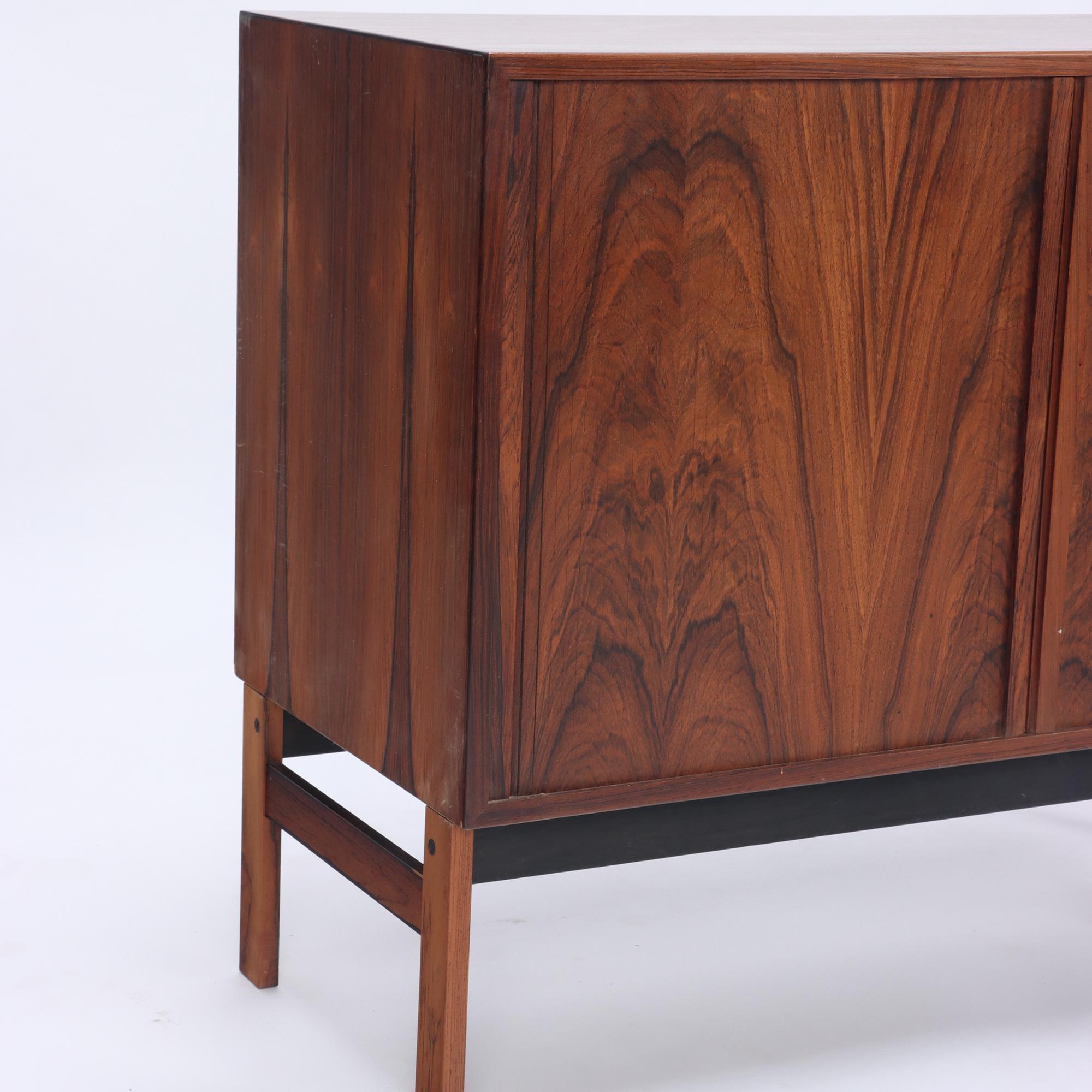 A Danish mid century rosewood media cabinet or small credenza having tambour doors and one interior shelf circa 1960. Labeled Danish Furniture Makers control.