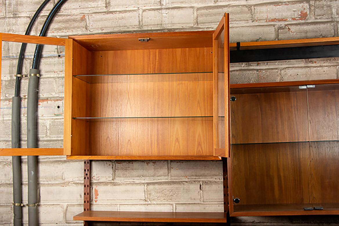 Scandinavian shelving unit/bookcase comprising:
- 8 shelves, each 22 cm deep
- A display cabinet with two wooden hinged doors opening onto two height-adjustable glass shelves, 30 cm deep and 65 cm high.
- A display cabinet with two hinged doors held