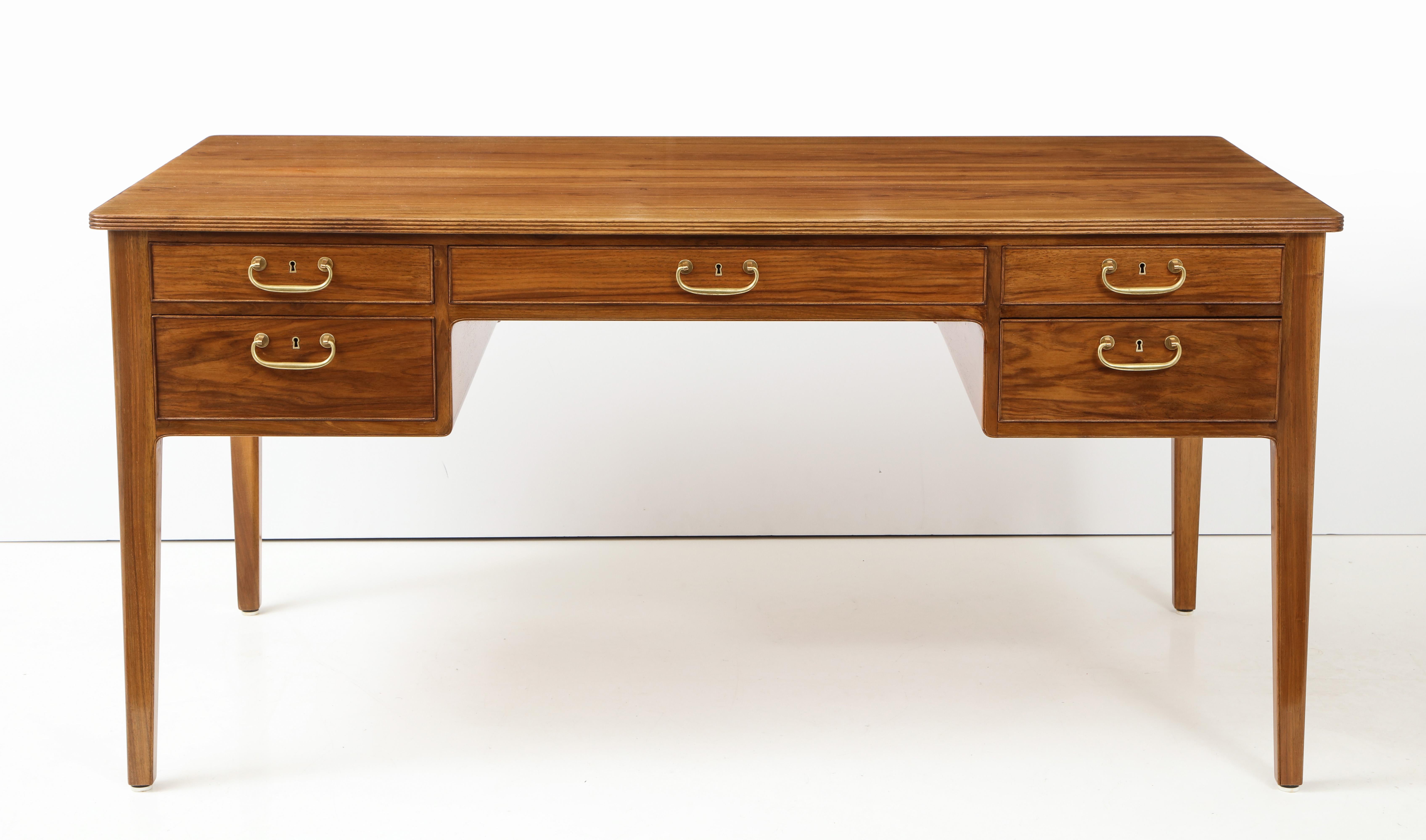 A Danish Ole Wanscher walnut writing desk, circa 1960s, the rectangular top with a reeded edge above five drawers raised on square tapered legs.