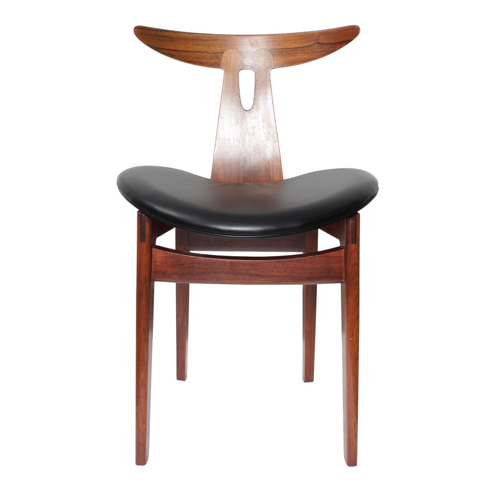 A sculptural side chair in rosewood with seat upholstered in original black leather.
Designed by Vilhelm Wohlert in 1958. Made by cabinetmaker Arne Poulsen, Denmark.