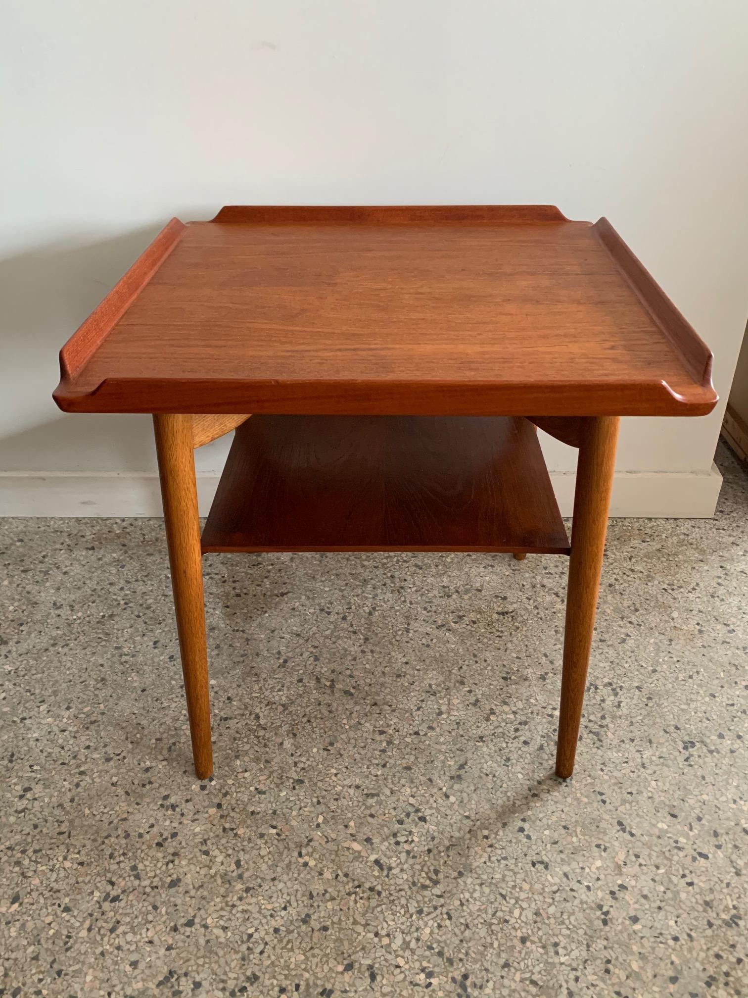 Ein klassischer Tisch mit erhöhter Kante von George Tanier, importiert aus Dänemark. Mit schwebender Platte, unterer Ablage und geschnitzten Eichenbeinen.