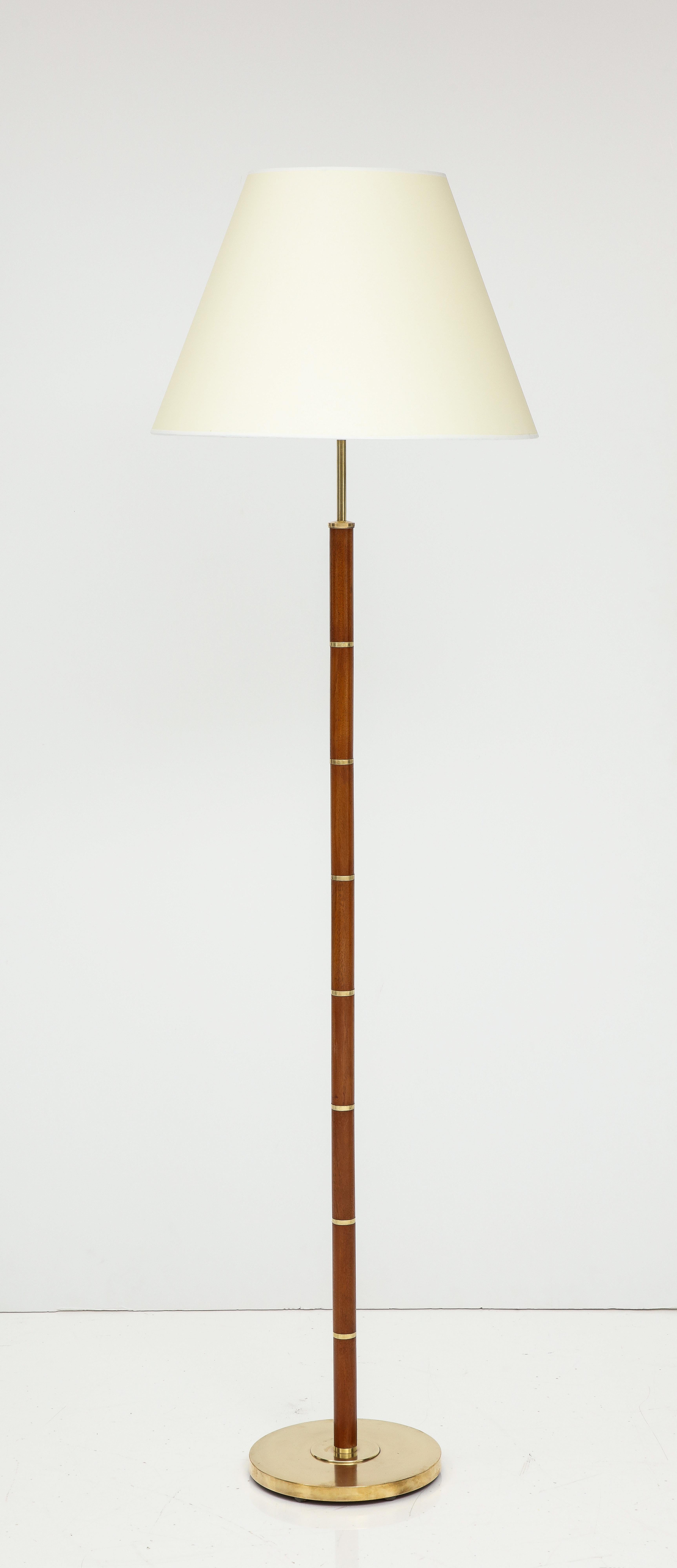 A Danish floor lamp, teak with brass bandings and a circular brass base, Circa 1960s. Attributed Fog & Mørup. Re-wired for US. New shade.
Measures: 70 in. high - to top of current shade 10.5 in. diameter. base.