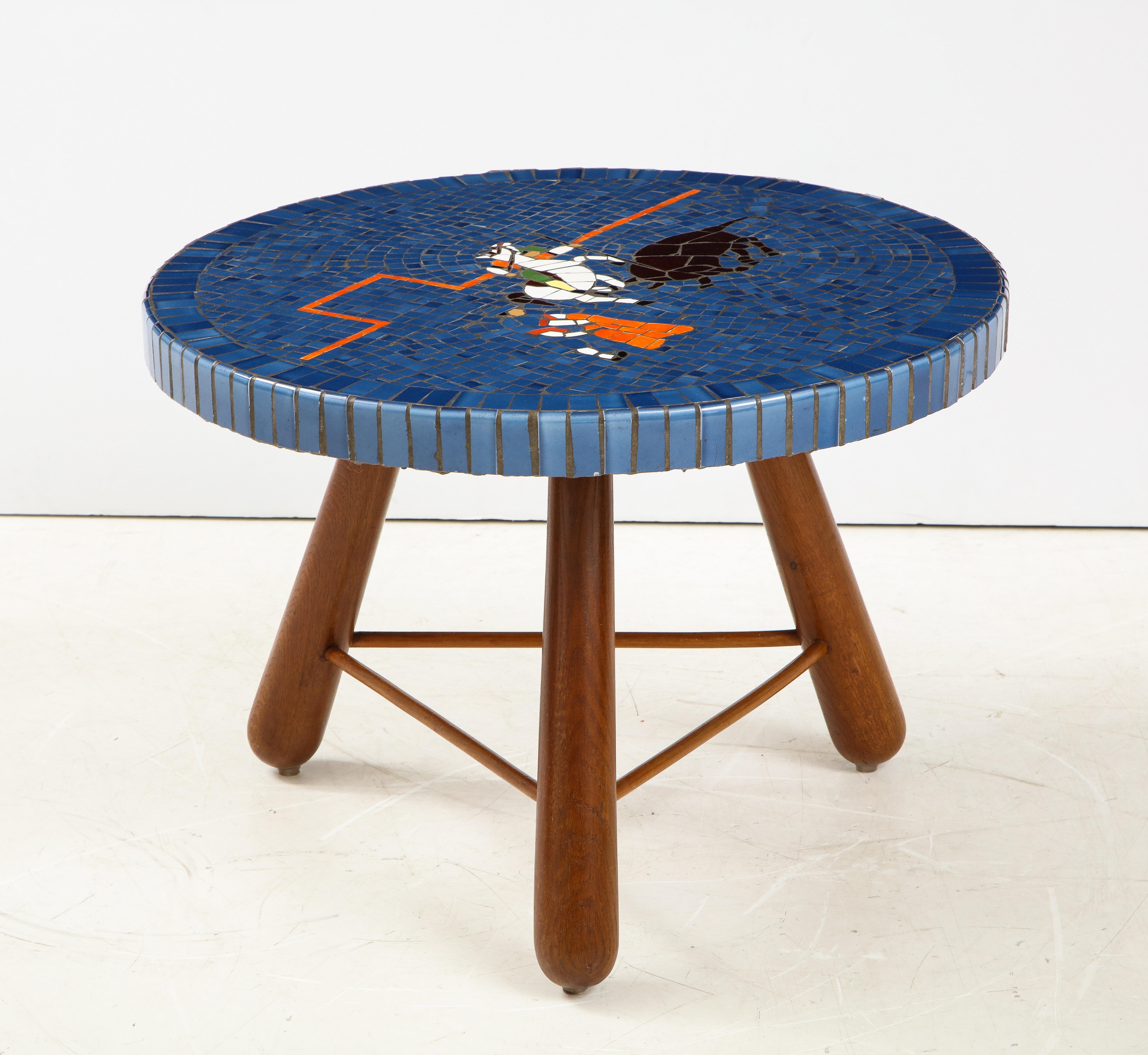 A Danish tile top and oak table, Circa 1940-50, attributed to cabinetmaker  Otto Færge and the top attributed to artist Paul Hedegård,  the circular top constructed with a concrete base set with colorful tile depicting a bull-fighting scene, raised