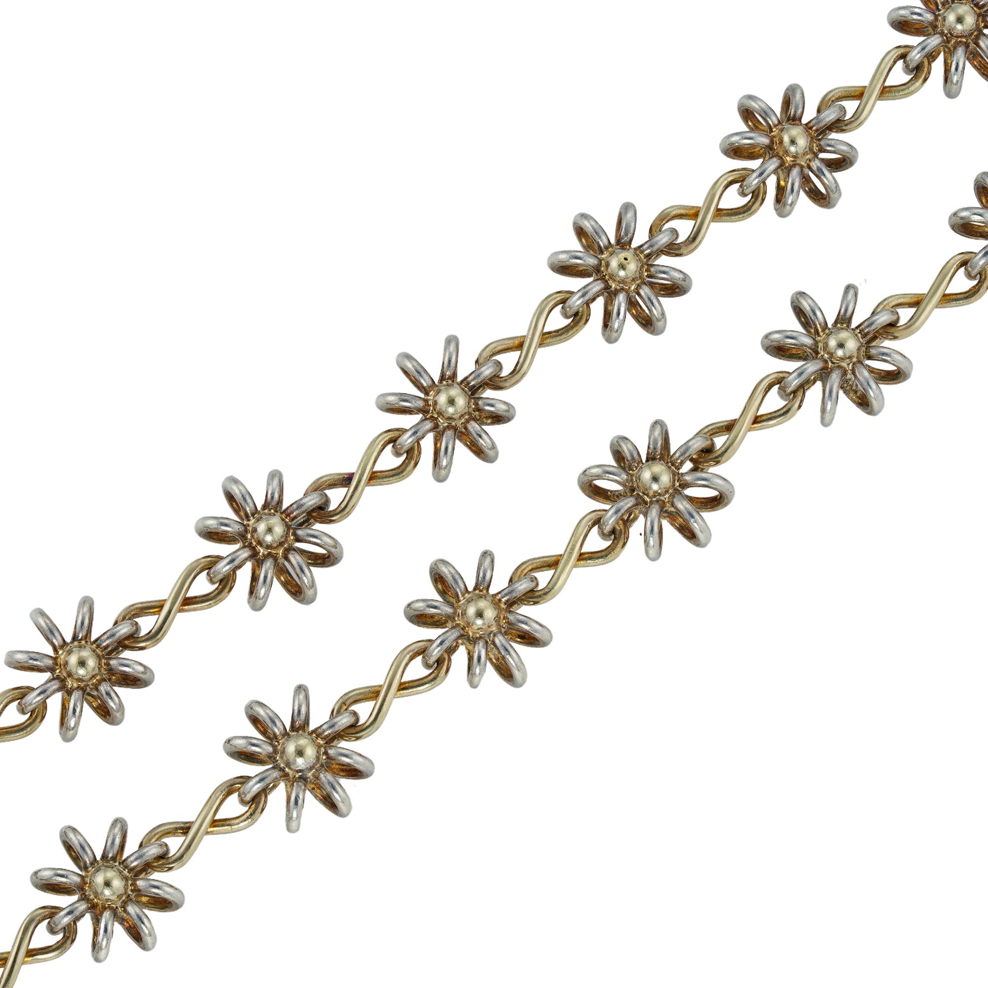 A Darcey Bussell necklace, handmade by Lucie Heskett-Brem, the Gold Weaver of Lucerne, the necklace comprising twenty seven large silver  uniform floral motifs with yellow gold figure-of-eight links, bearing common control marks for 18 carat gold,